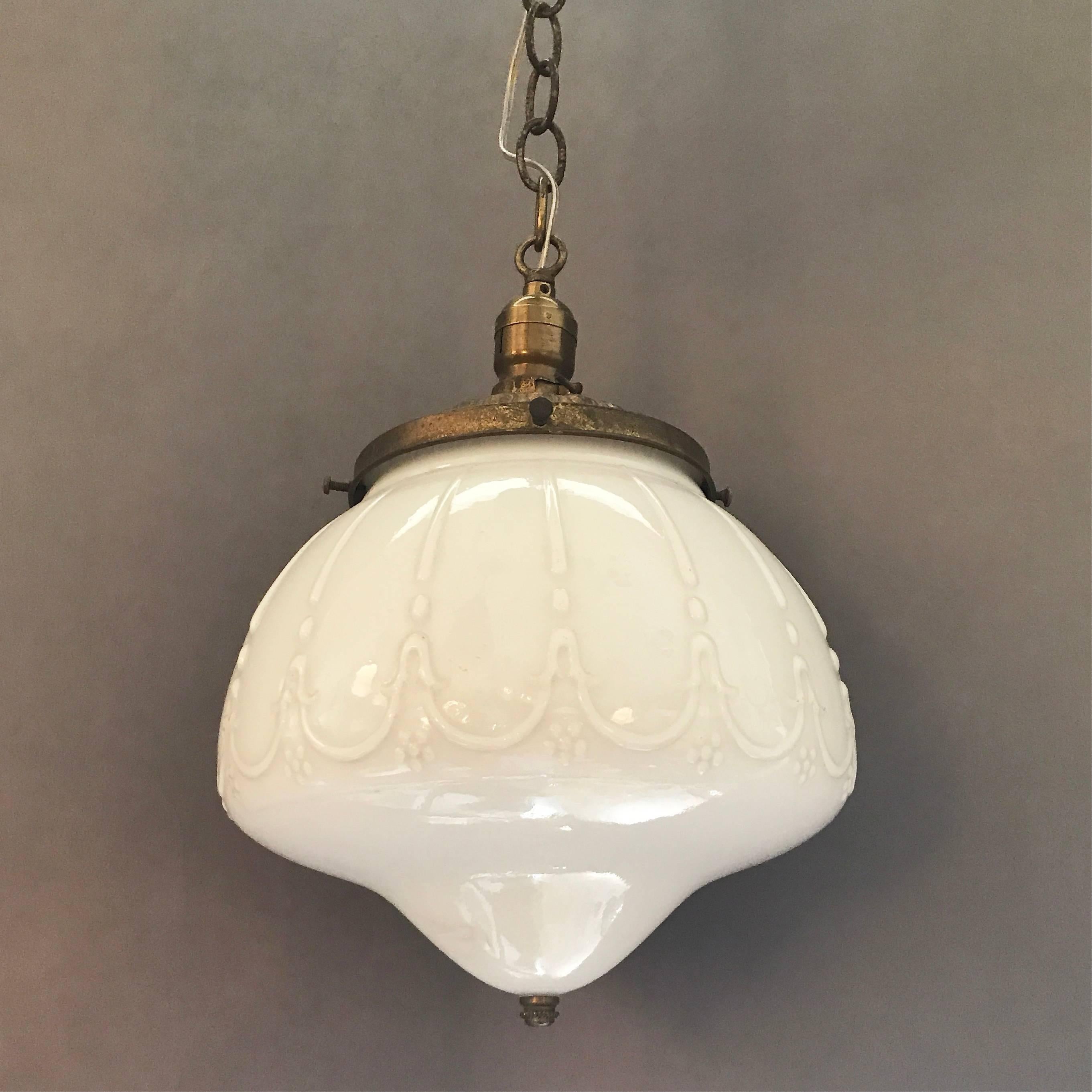 Early 20th century, decorative, milk glass, library pendant with brass fitter, chain and canopy. Newly wired for 200 watts.

Over height: 42in. ht.