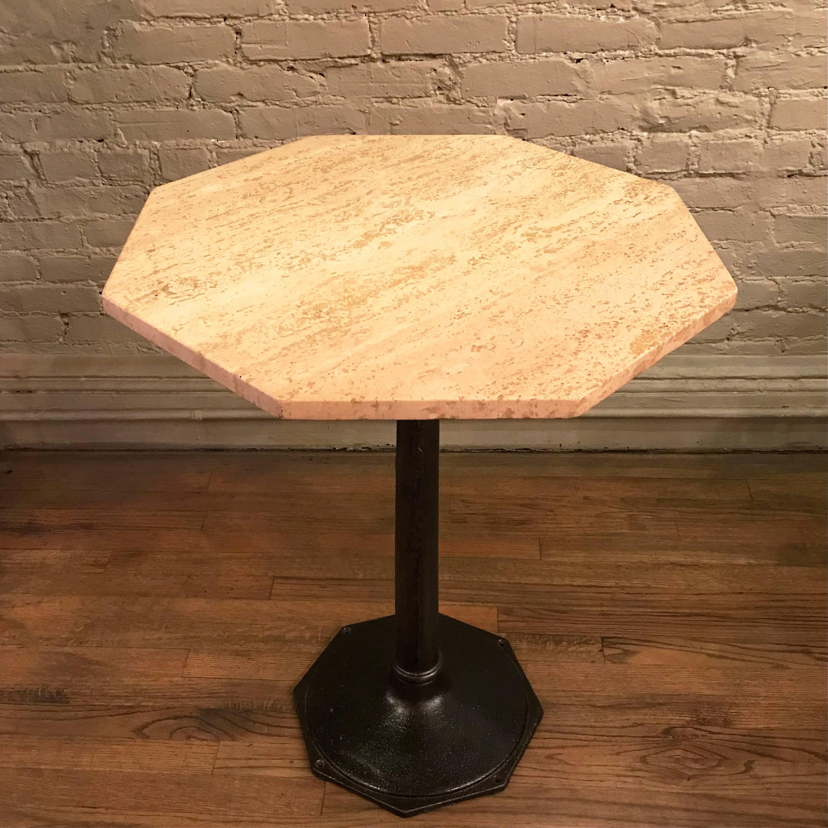 Bistro, café, dining table features a 1930s, cast iron octagonal pedestal base paired with an octagonal, travertine stone top.