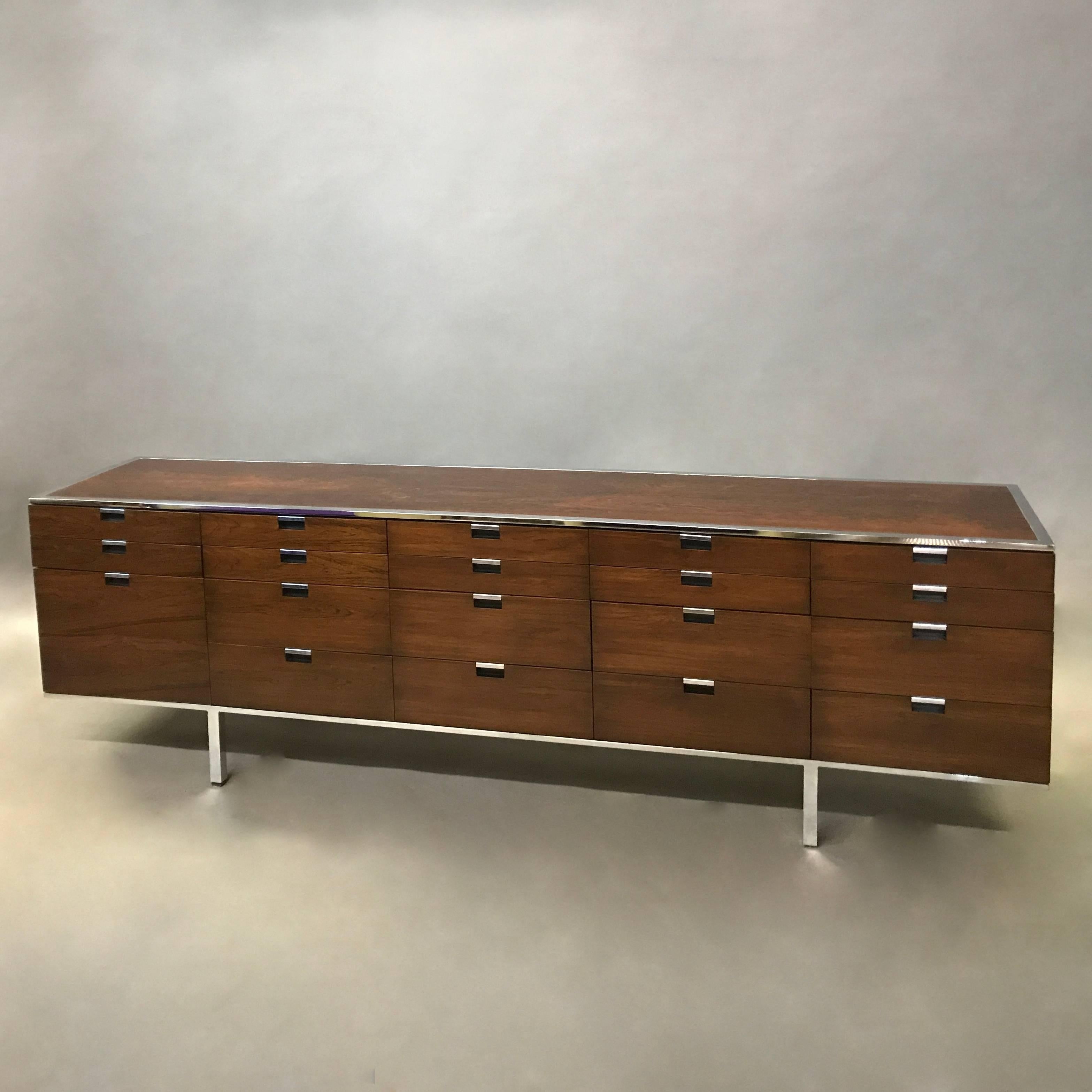 Long, sleek, rosewood credenza designed by Roger Sprunger for Dunbar features a chrome frame and recessed pulls on it's 19 drawers of various size.