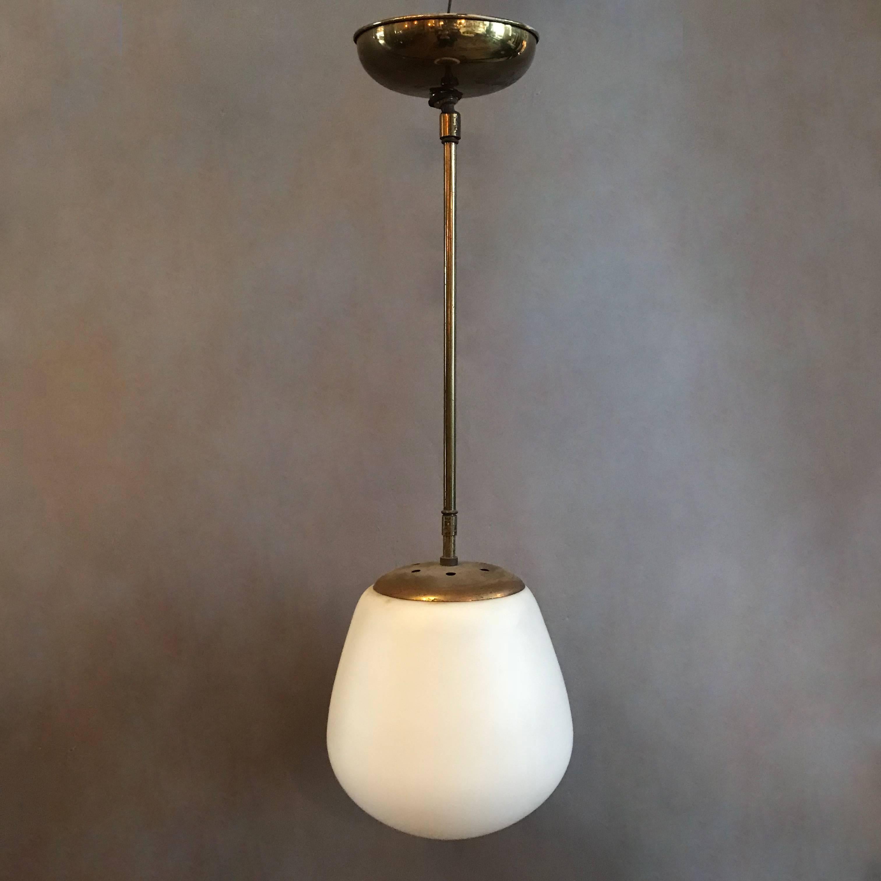 Danish Modern pendant light features a frosted white, size 8 in x 8 in oblong shade with brass pole and canopy.
