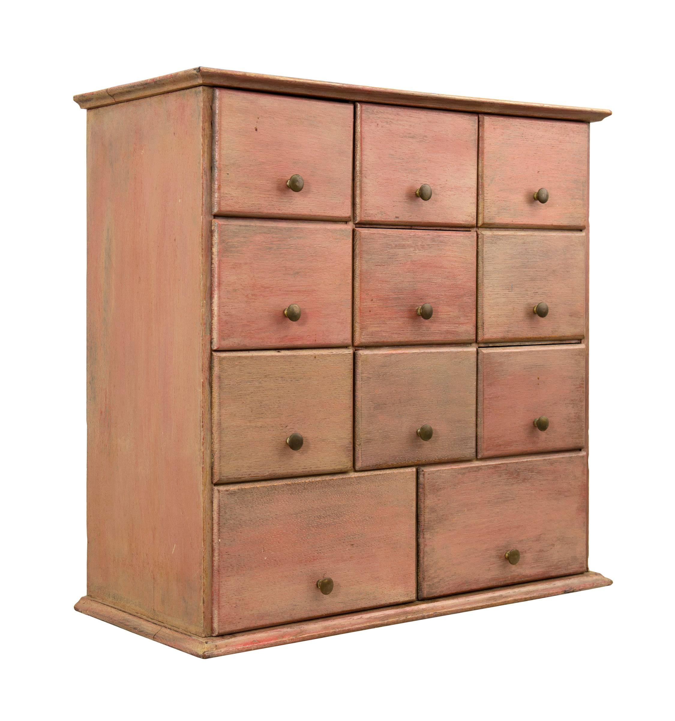 Great hanging spice or sewing cabinet with old salmon painted surface, American, circa 1900.
