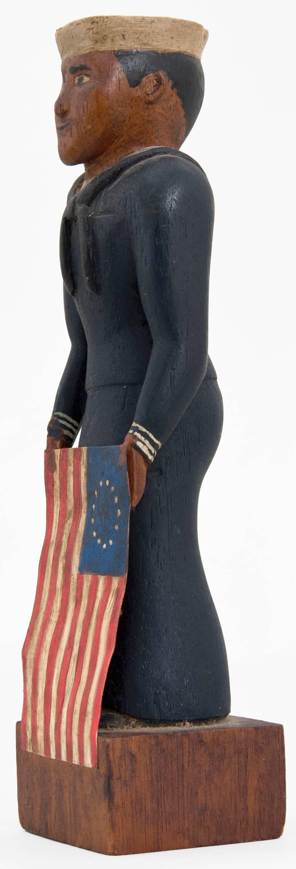 Very interesting carved Folk Art figure of a sailor. Carved and painted wood. Flag is painted heavy paper. Measures: 7 1/4