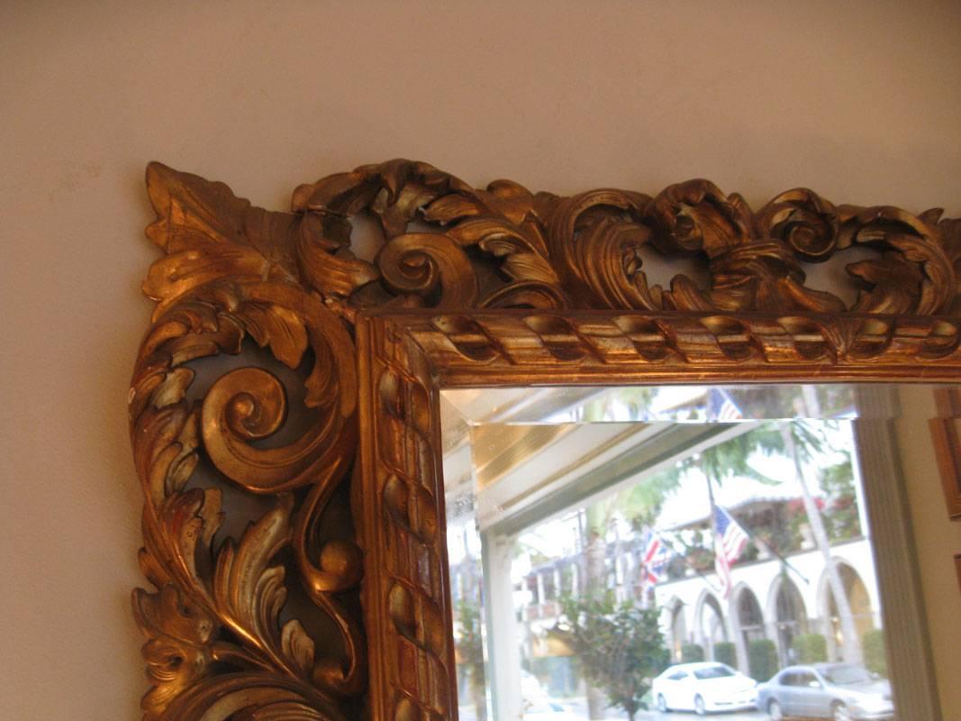 French carved giltwood mirror 
Napoleon III period.
Elaborated carving of scrolls and leaves.
7' wide carving around a fluted /ribbon design straight frame.


 