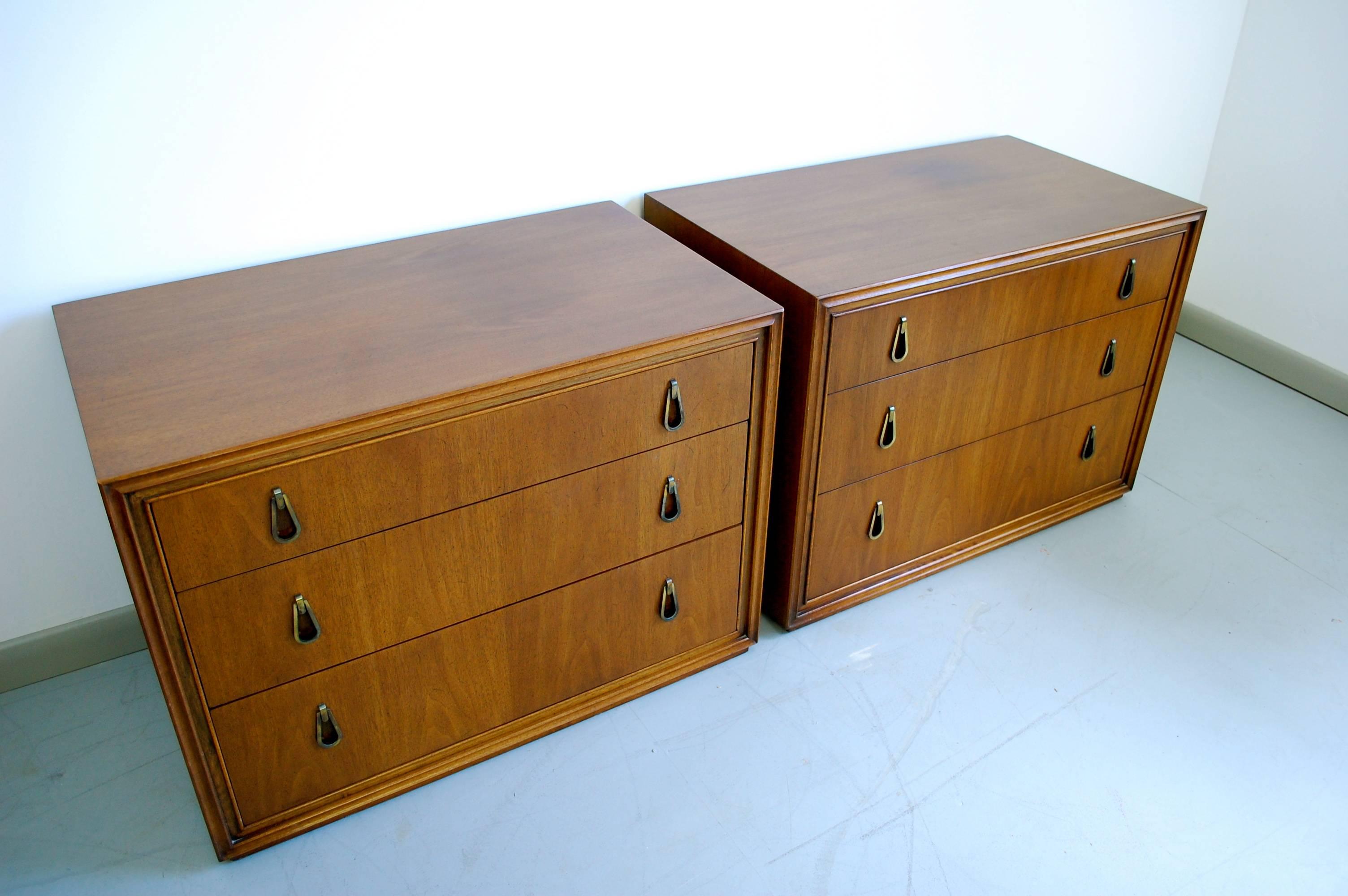 Sophisticated Mid-Century Modern nightstands by John Stuart for Mount Airy Furniture in walnut with gorgeous wood grain and handsome tear drop brass pulls with a beautiful patina.
   