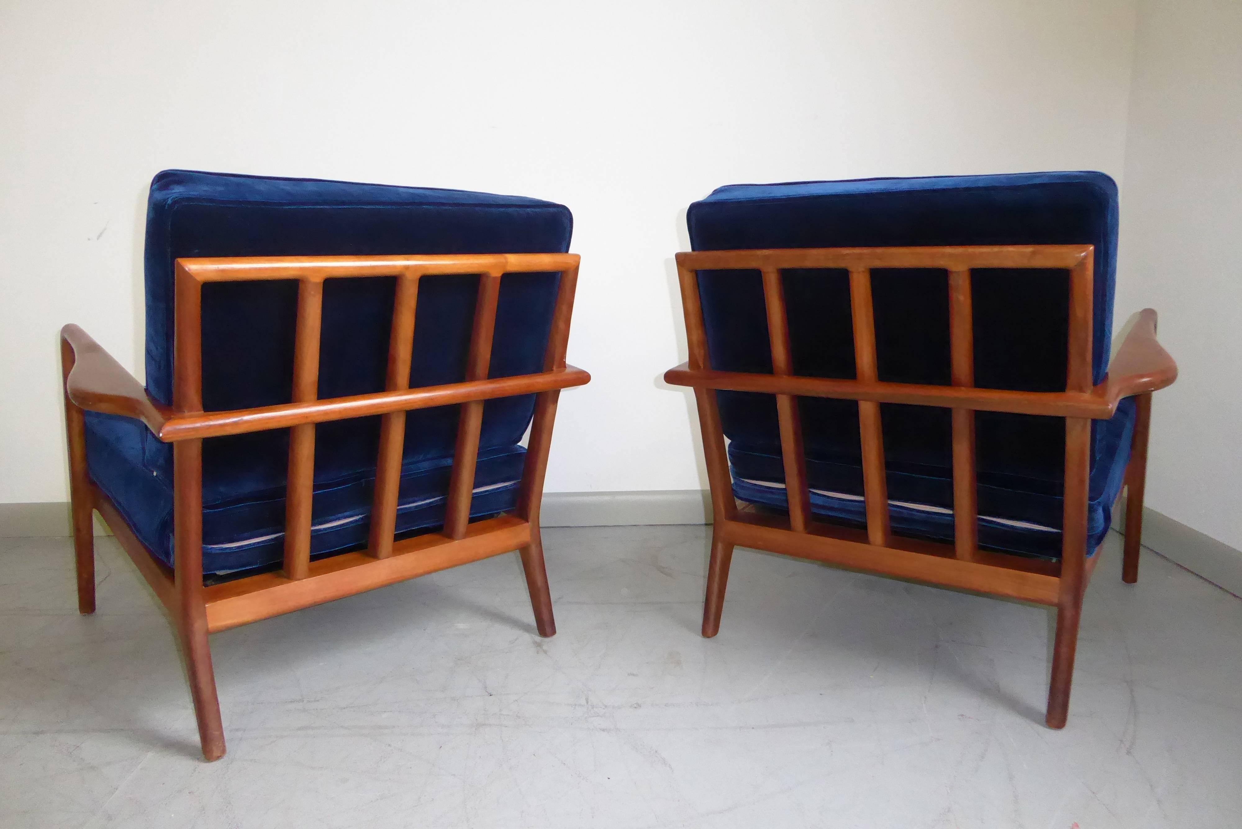 Gorgeous pair of sculptural walnut lounge chairs by Mel Smilow, 1960s. Newly reupholstered in a deep indigo velvet, this pair of chairs are stunning from all angles.