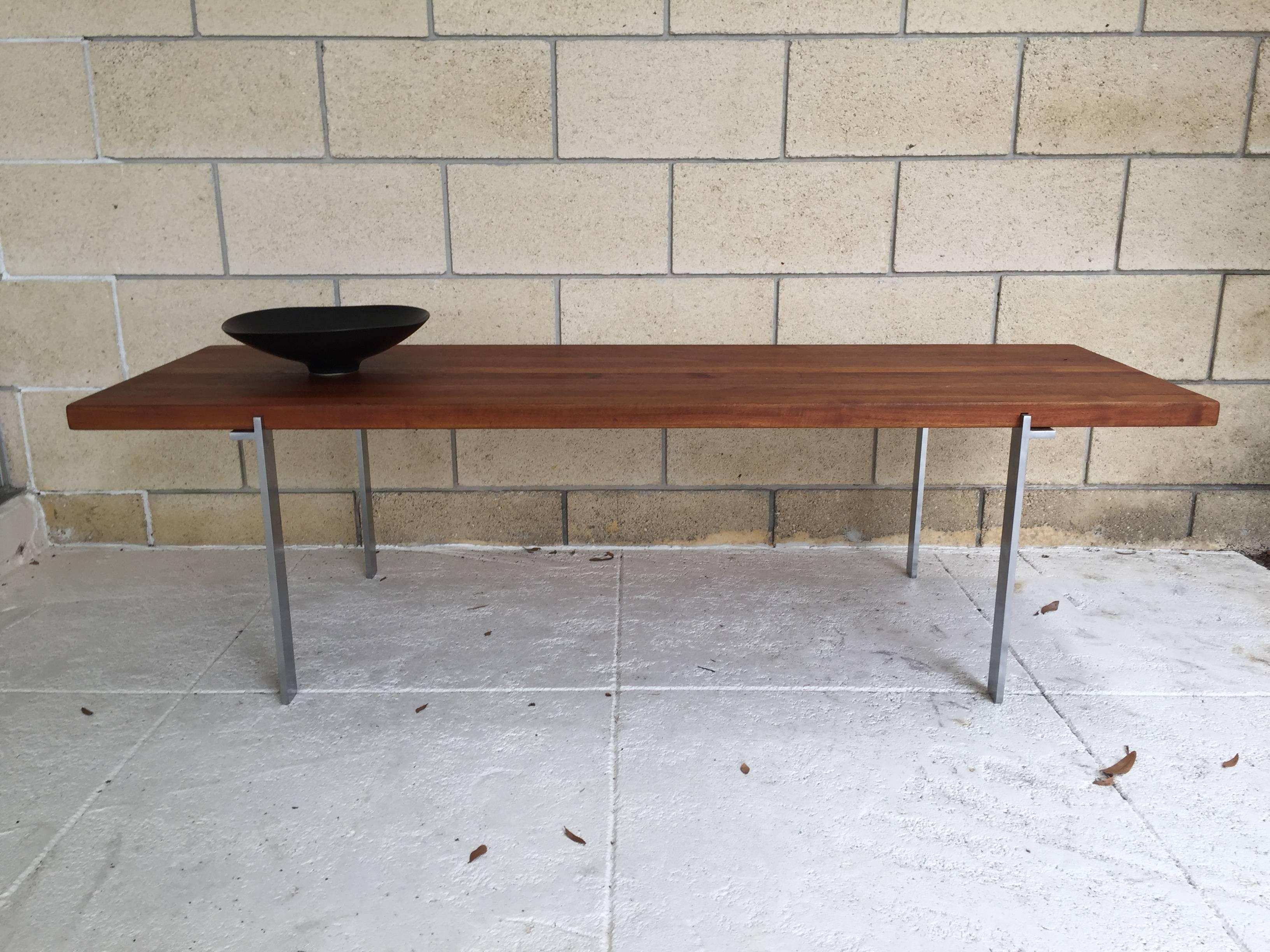 Beautiful Minimalist solid teak and stainless steel coffee table in the manner of Poul Kjaerholm or Illum Wikkelso. Maker is unknown. The table is in original condition and made of thick solid teak planks with stainless steel legs. Some wear on the