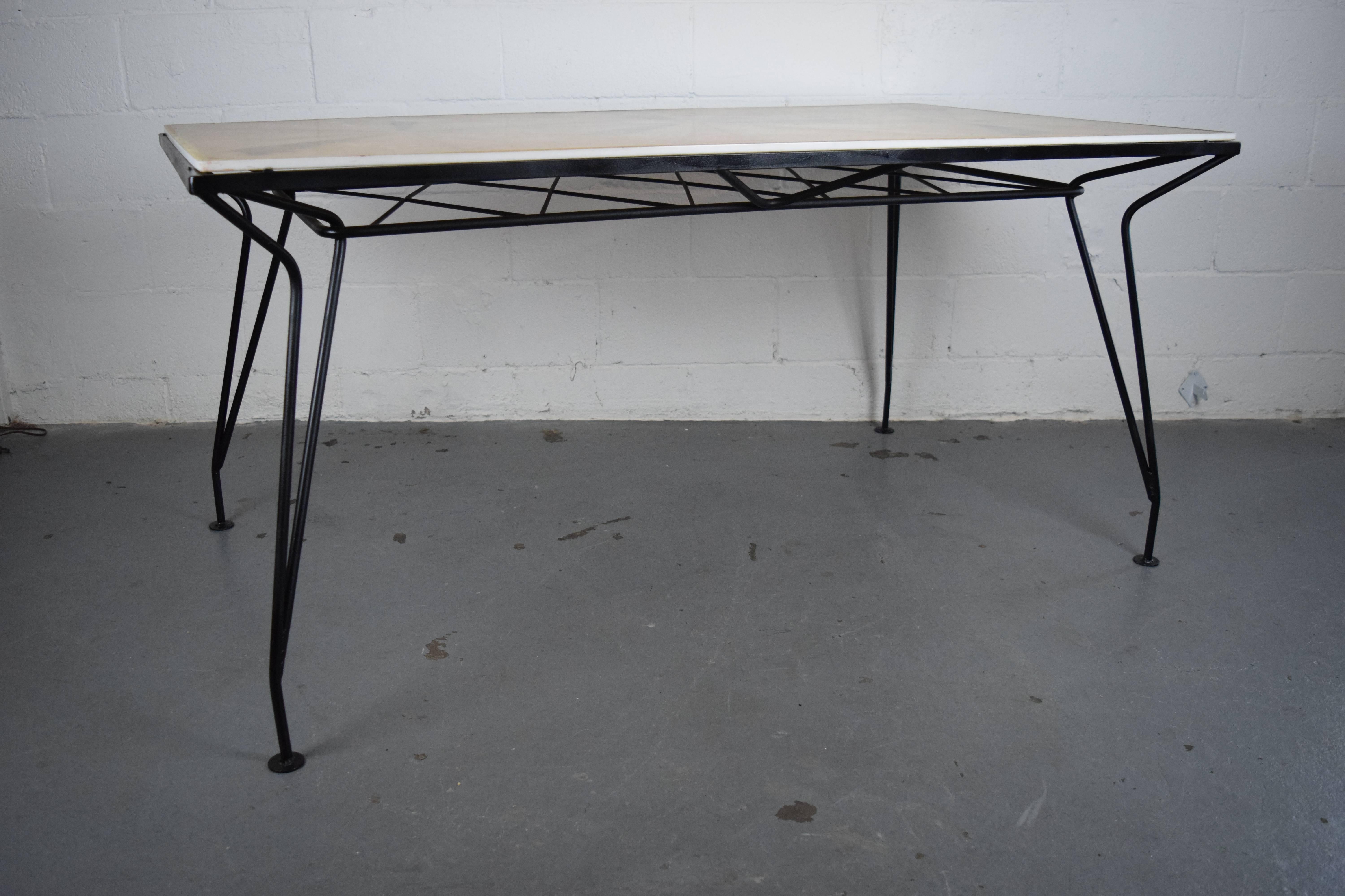 1950s iron patio table designed by Maurizio Tempestini for Salterini with a custom fiberglass and resin top. The base has been restored. Some wear on the tabletop - please see pictures.