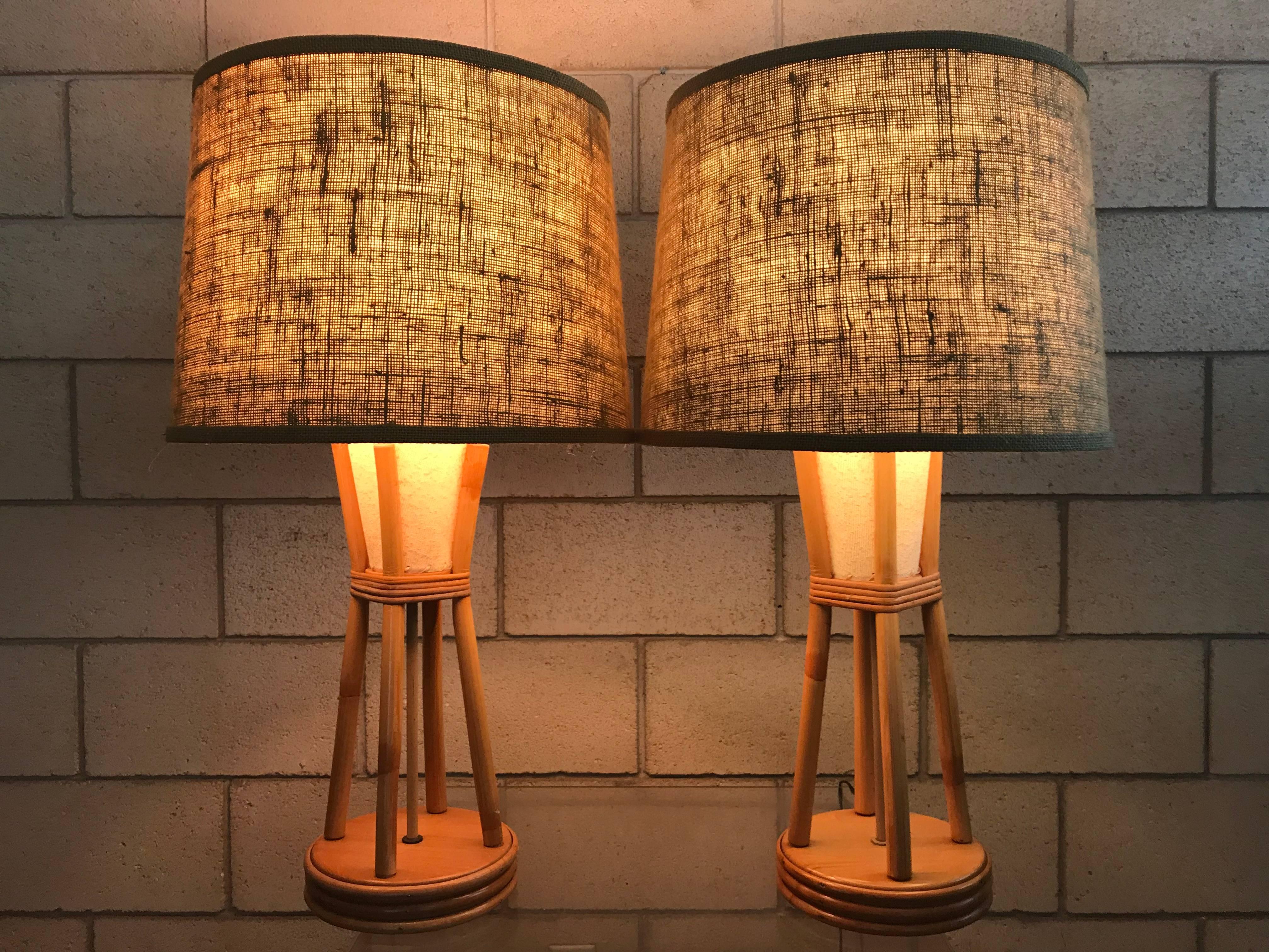 Wonderful pair of Paul Frankl style Mid-Century Modern Bamboo Tiki lamps. These lamps have the original bamboo finals. Burlap shades and diffusers. One lamp probably was re-wired a while back which is why the cords have two colors. Both work great