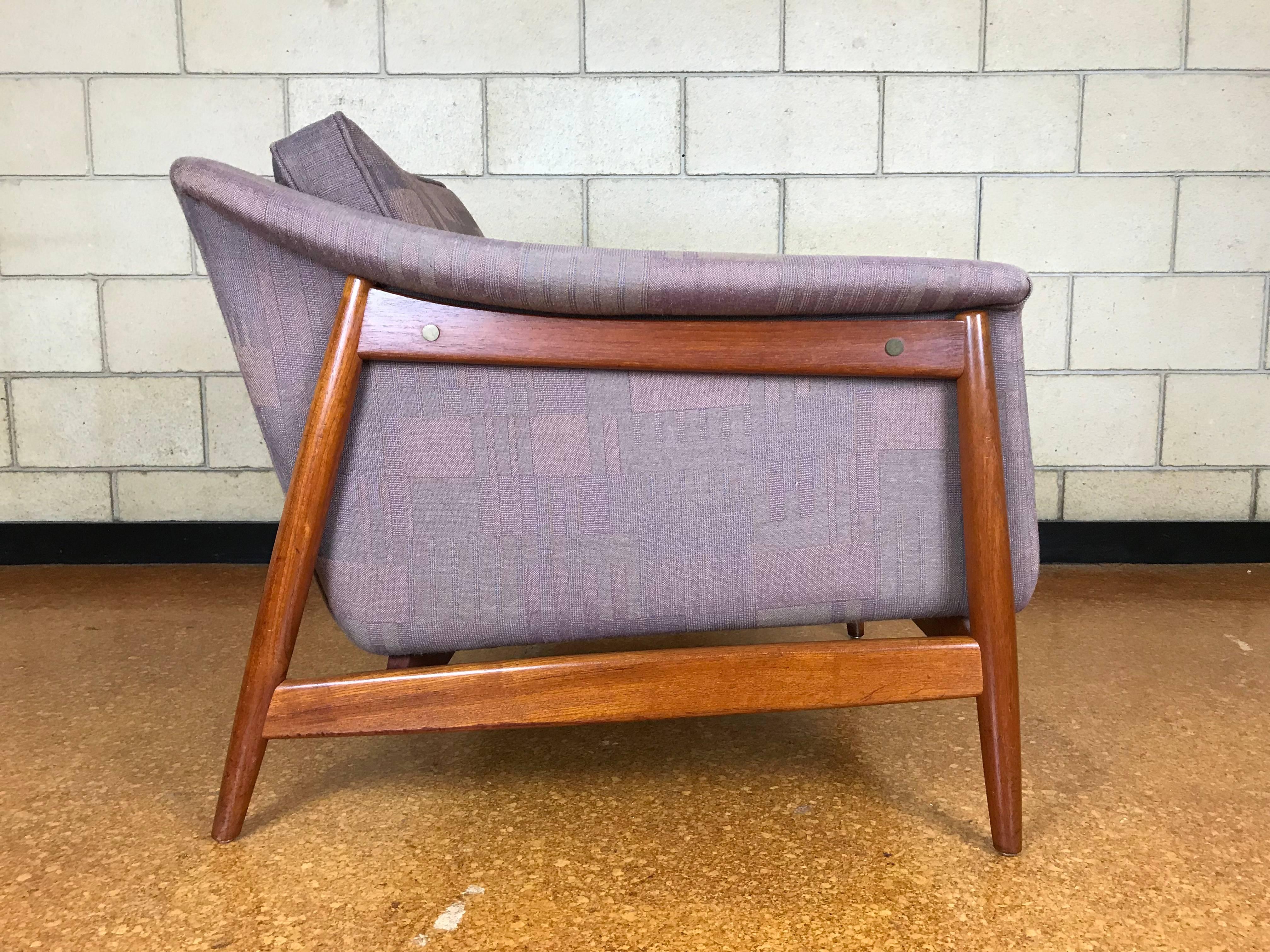 Beautiful and sturdy 'floating' lounge chair designed by Folke Ohlsson for DUX Furniture of Sweden. The legs and frame are made of a combination of teak and rosewood. This is a very solid chair and was reupholstered years ago and needs new