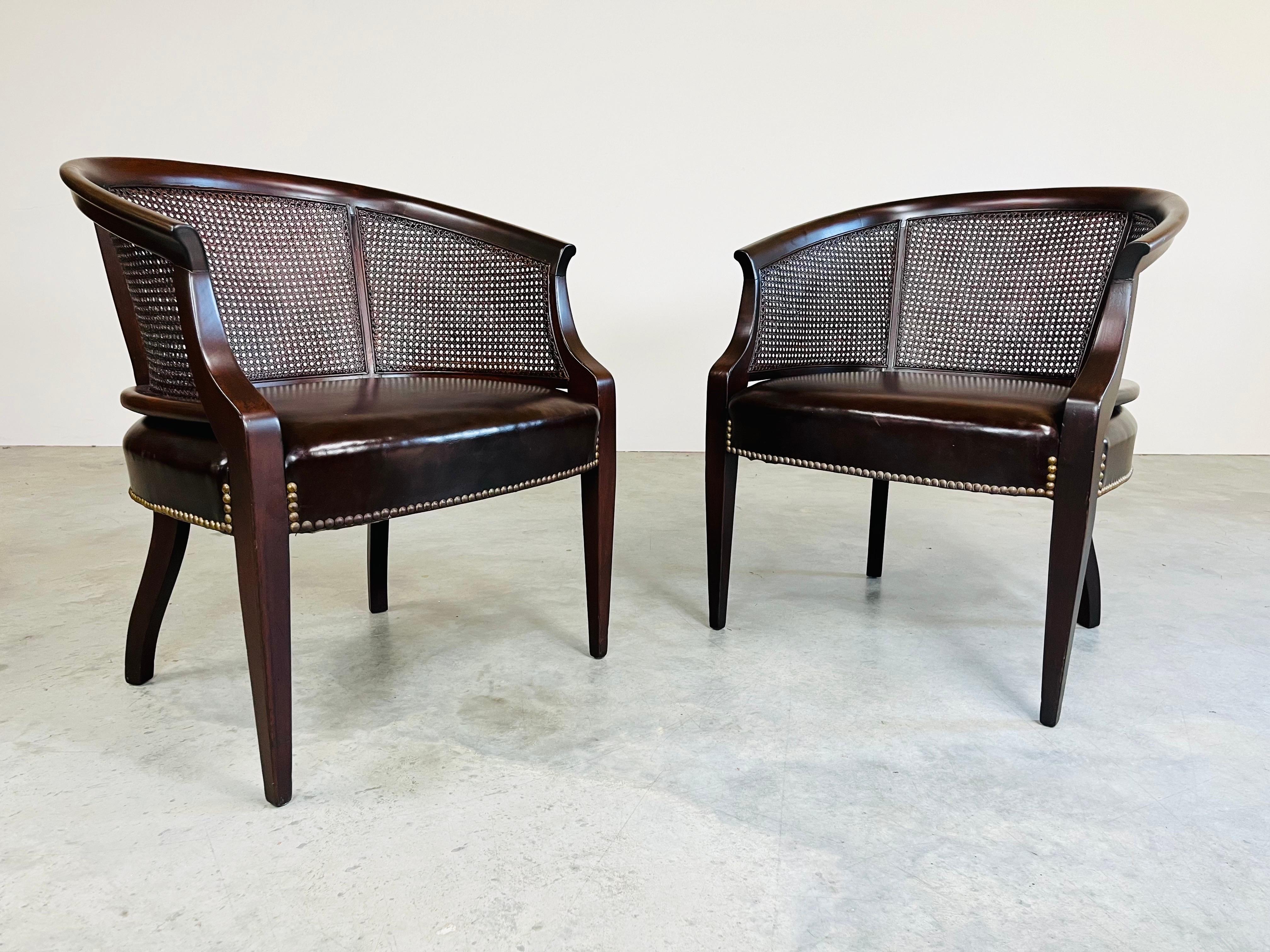 A beautiful matched pair of cane barrel back club chairs with lithe front legs by Hickory Chair Co. having beautiful, supple original leather. 1960’s production. 
Beautiful, clean condition. No breaks or punctures to any of the caning. Structurally