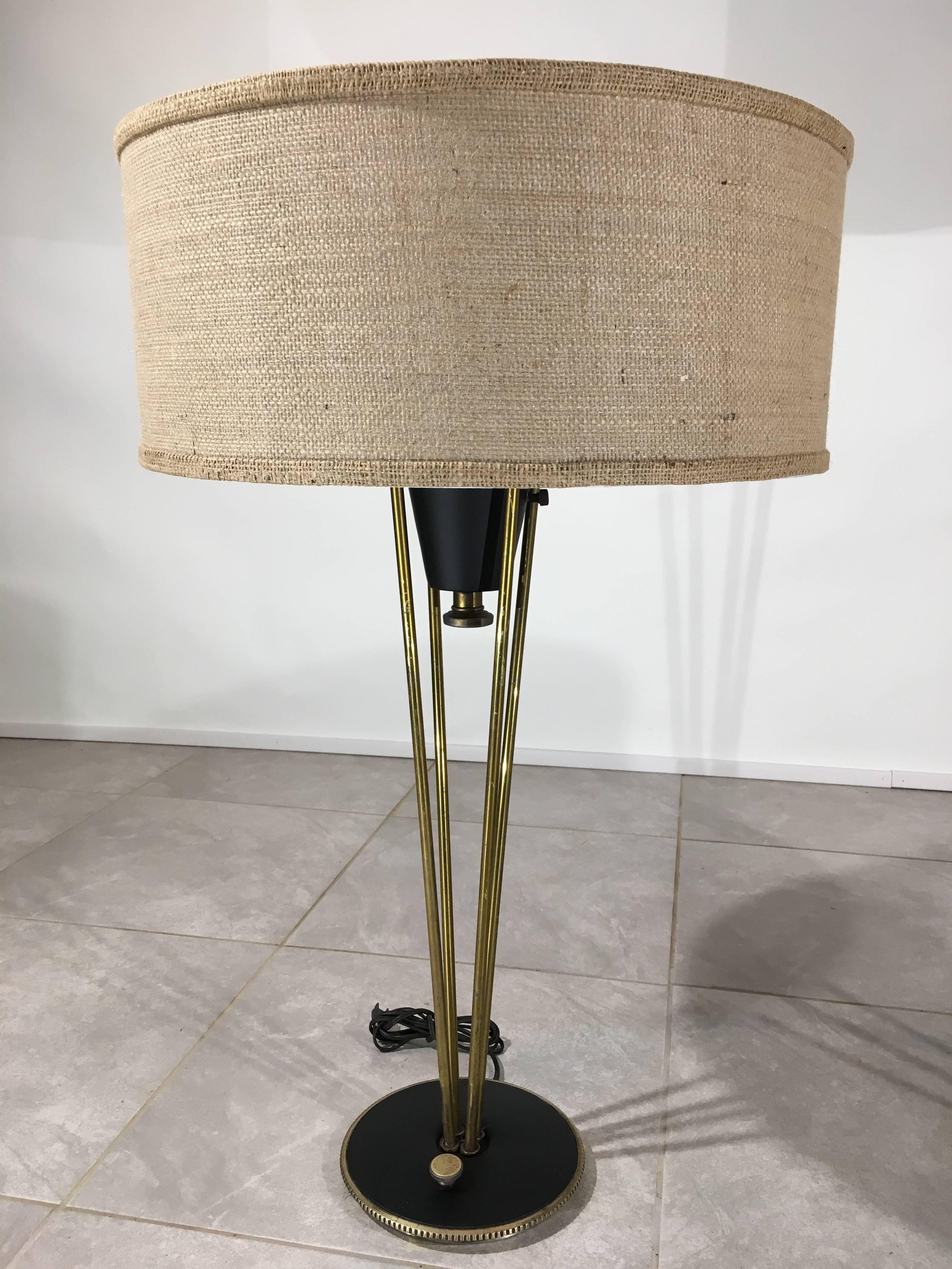 An attractive pair of vintage atomic era rocket lamps having brass stems and ebonized steel bases with solid brass turn switches. 
Shades have been recently re-wrapped with burlap to maintain their original integrity. 
Very nice vintage condition.