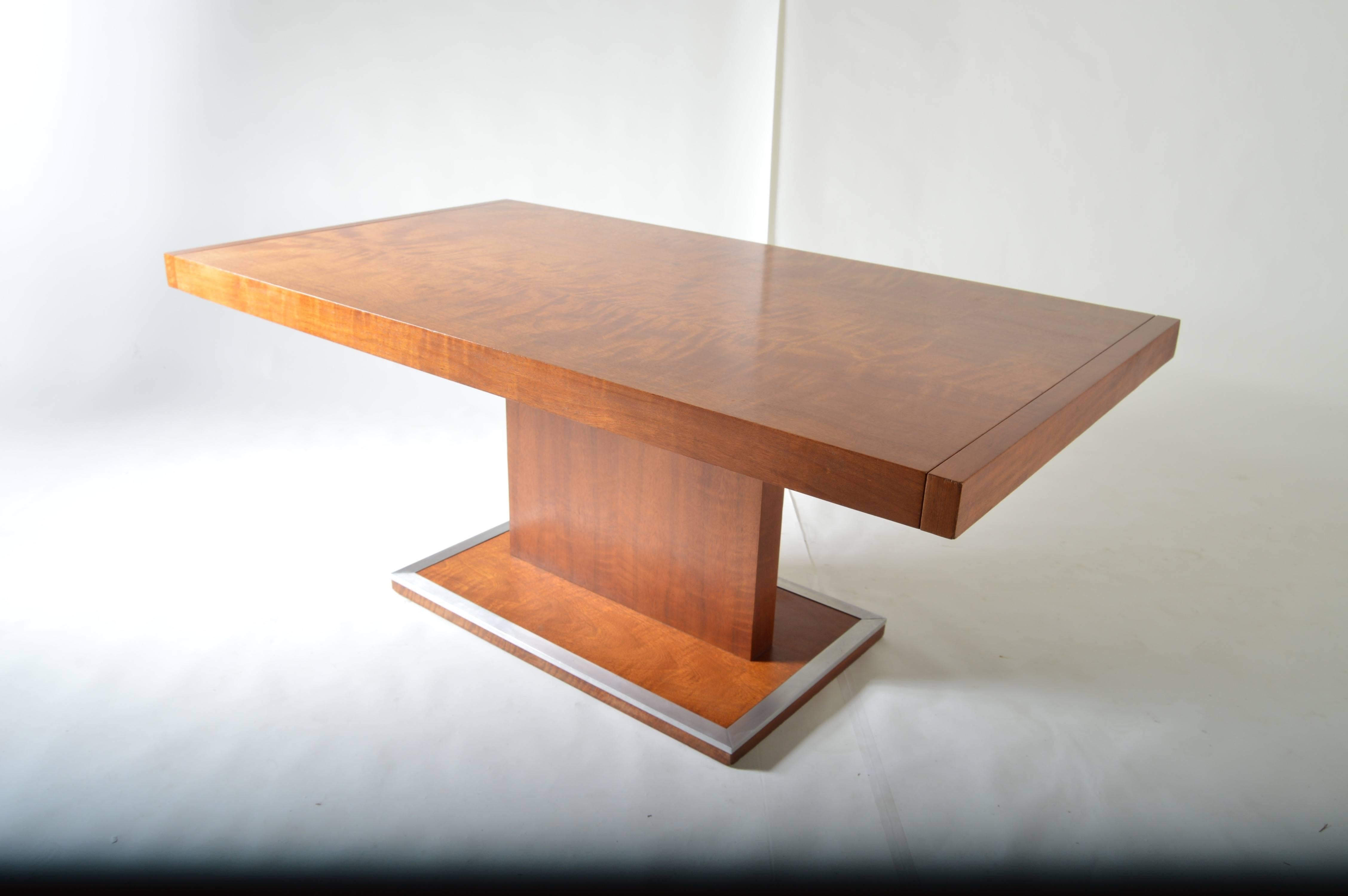 An adjustable full length dining table attributed to Milo Baughman for Founders having polished aluminum trim at the base. 

Width without leaves is 68