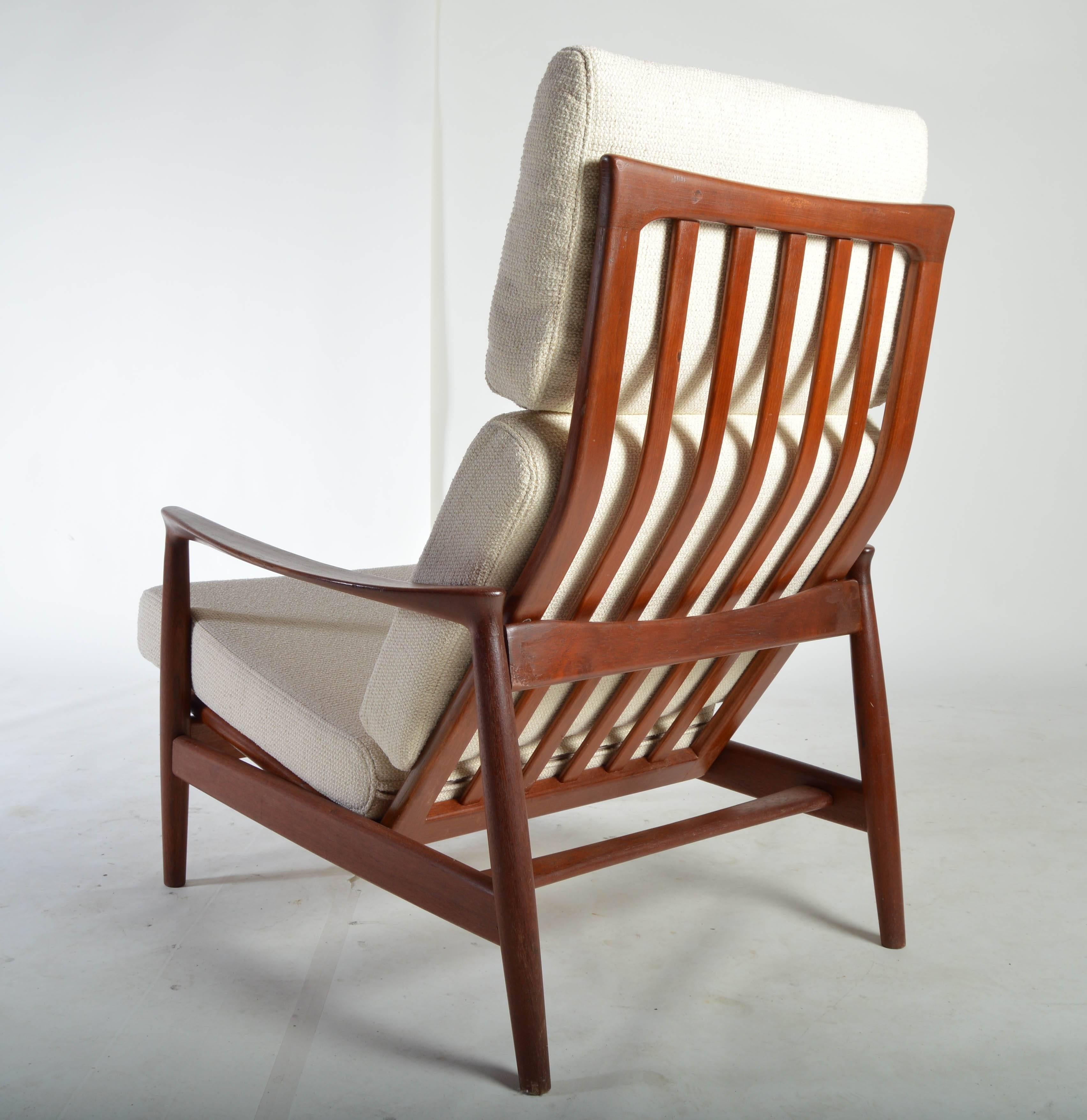 A beautiful high back lounge chair having teak frame and soft tweed upholstery designed by Folke Ohlsson for DUX, Sweden.