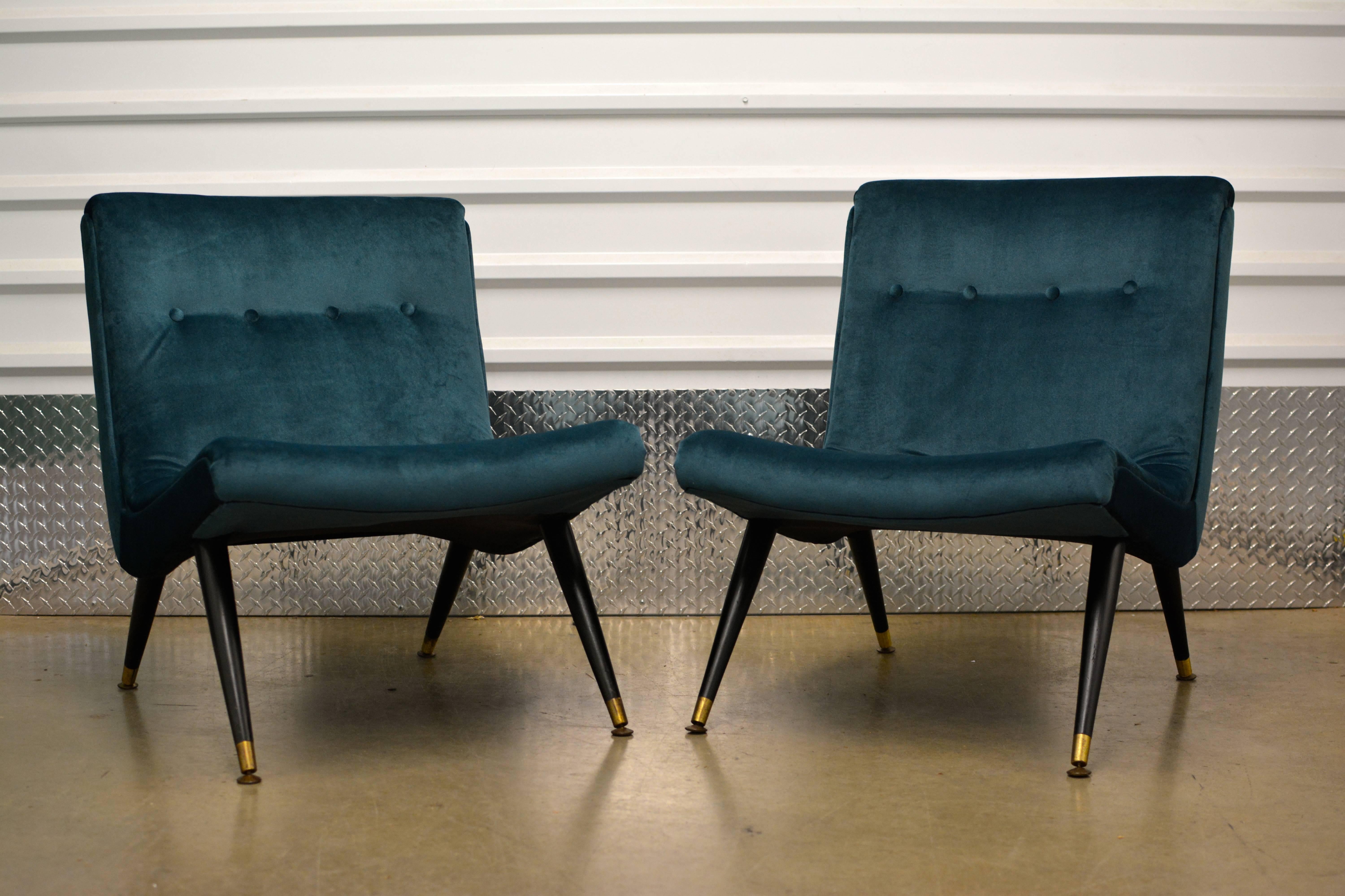 Outstanding pair of scoop lounge chairs attributed to Milo Baughman. Newly reupholstered in a stunning peacock velvet. Lacquered walnut legs with patinaed brass feet. Stunning pair of chairs with fabulous design and detail. 
