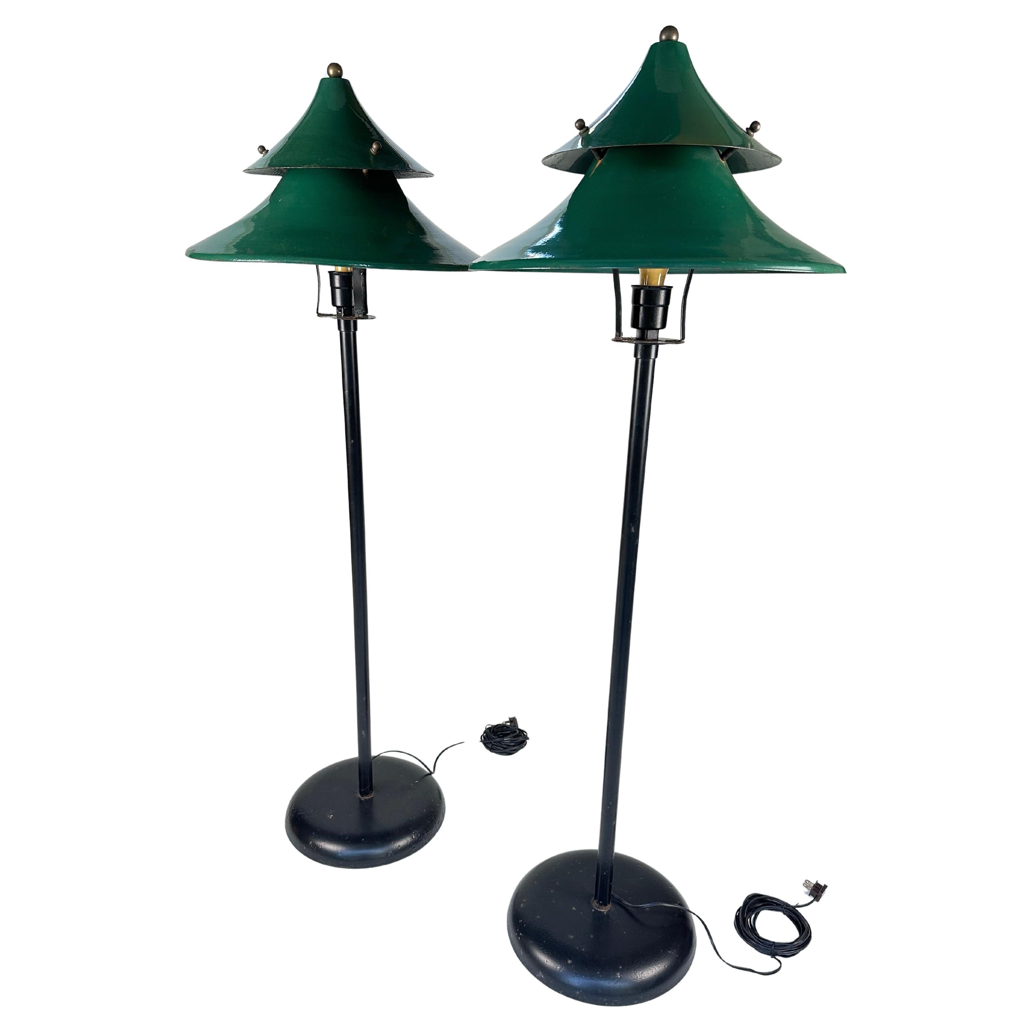 A stunning pair of original industrial floor lamps from the 1940s, featuring their original green powder-coated finish. These lamps boast heavyweight cast iron bases, ensuring both stability and timeless durability. Each lamp is topped with brass