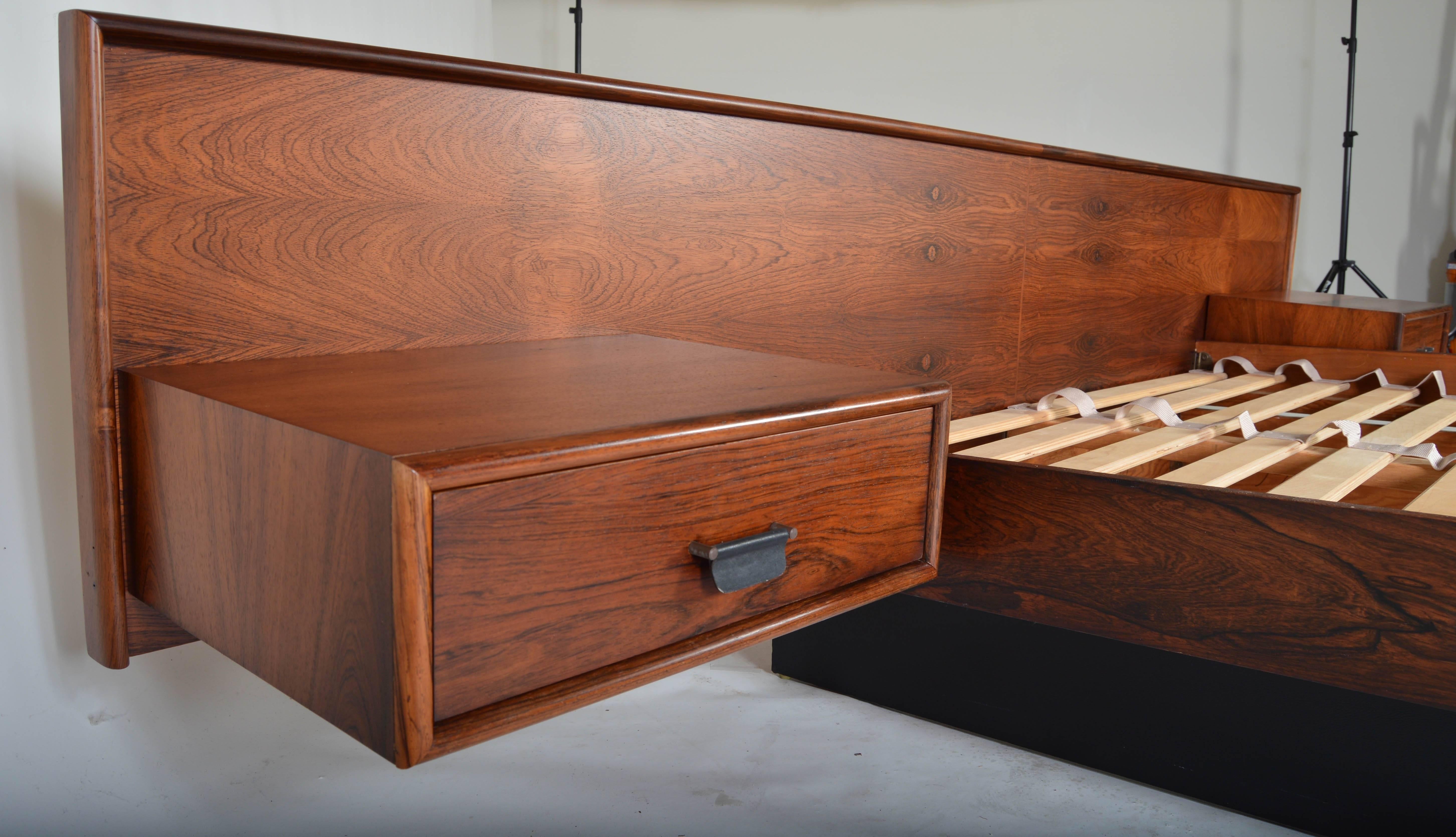 An absolutely stunning rosewood queen size bed in the manner of Hans Wegner having floating nightstands with leather pulls for the drawers. 

Dimensions: Headboard height 26