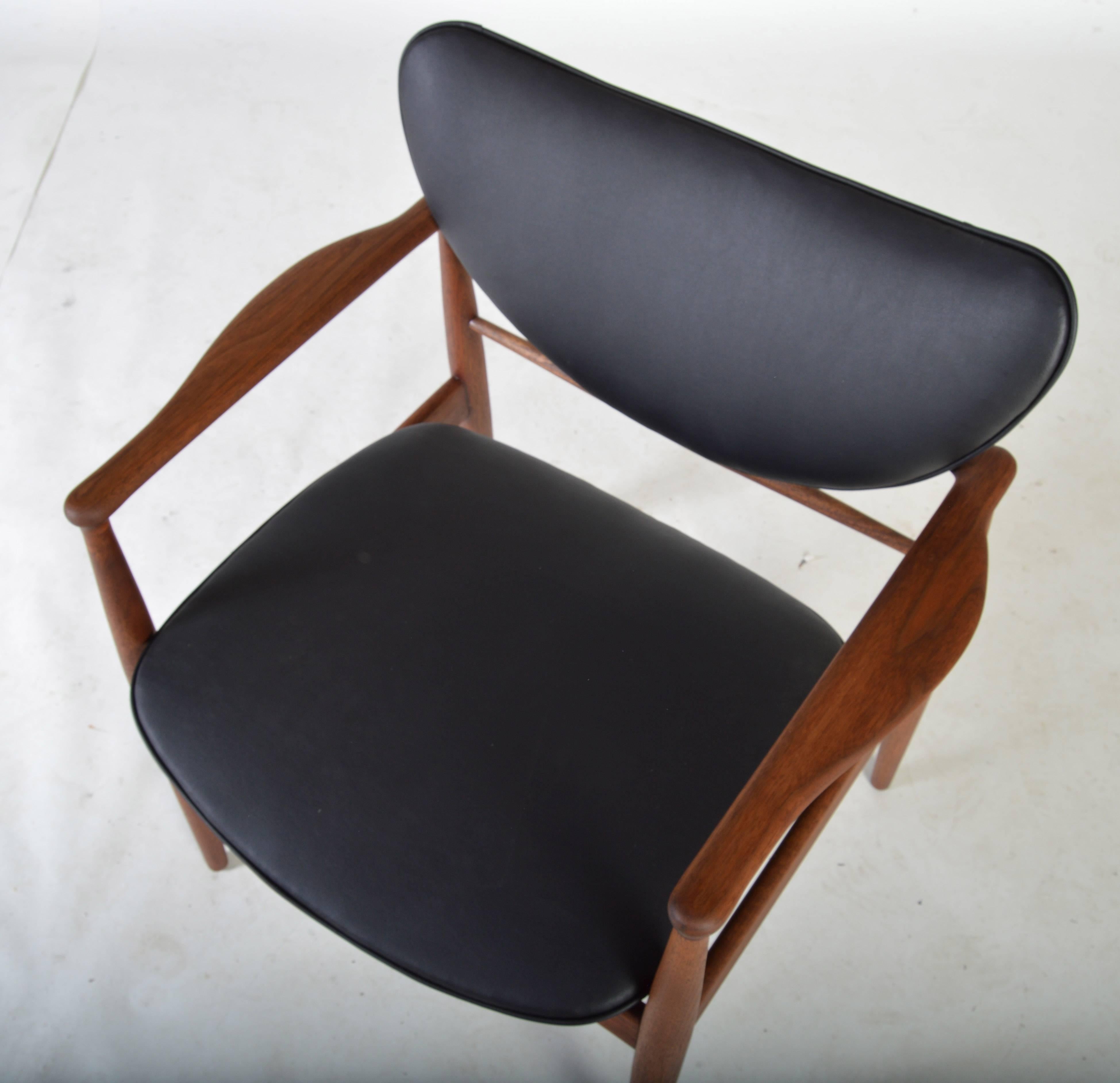 A stunning design by a true master. The no. 48 open armchair is a true favorite having walnut frame and sexy black leather curved backrest and seat. Newly reupholstered for the new owner to break in. Wood in excellent condition. Well maintained