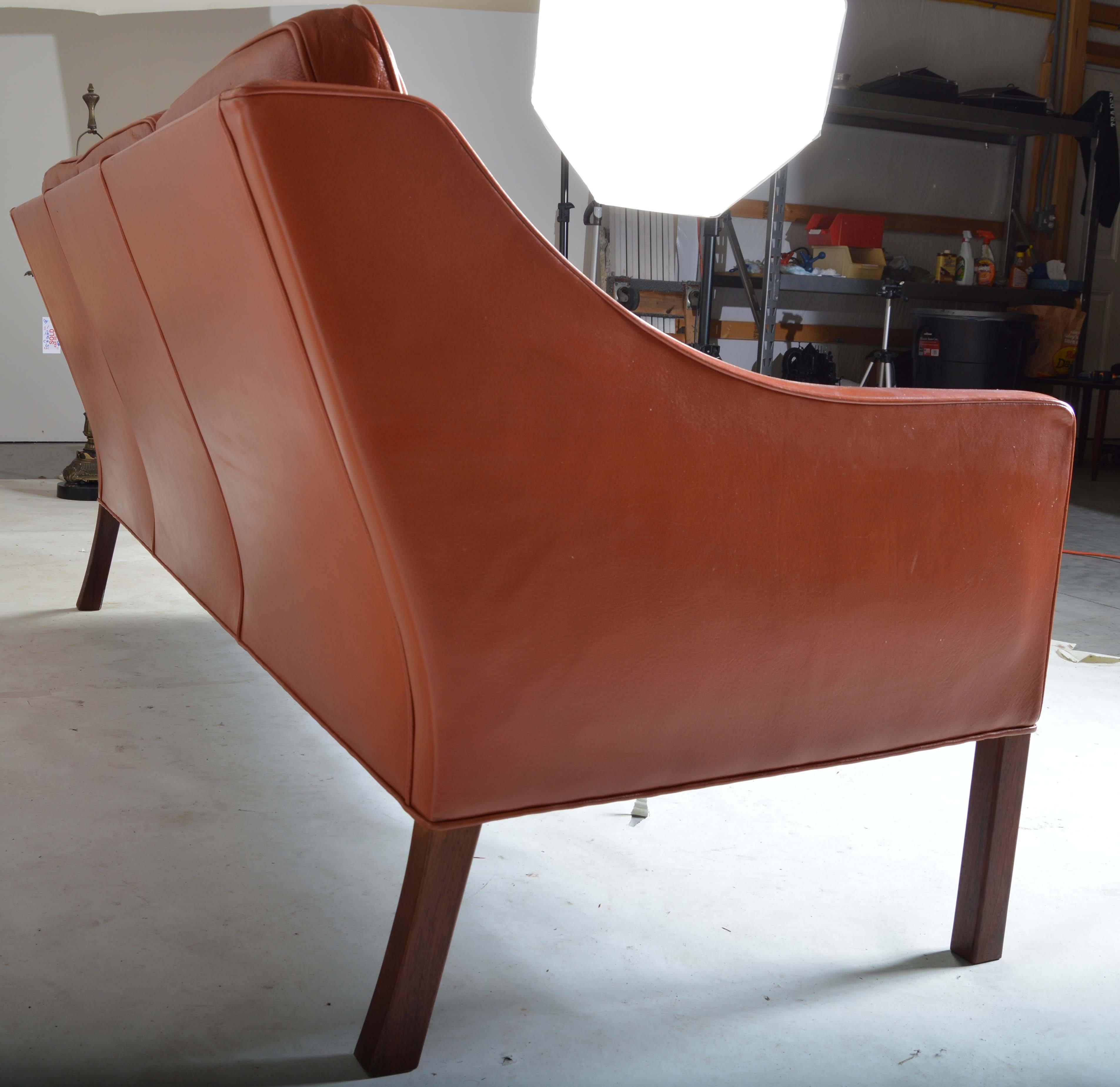 A beautiful, 1978 example of Børge Mogensen's model 2209 leather sofa having burnt orange leather over mahogany legs. 
 Well maintained with typical ware due to age. 
 This is an earlier example produced in 1978 and is very rare. 
 Solid,