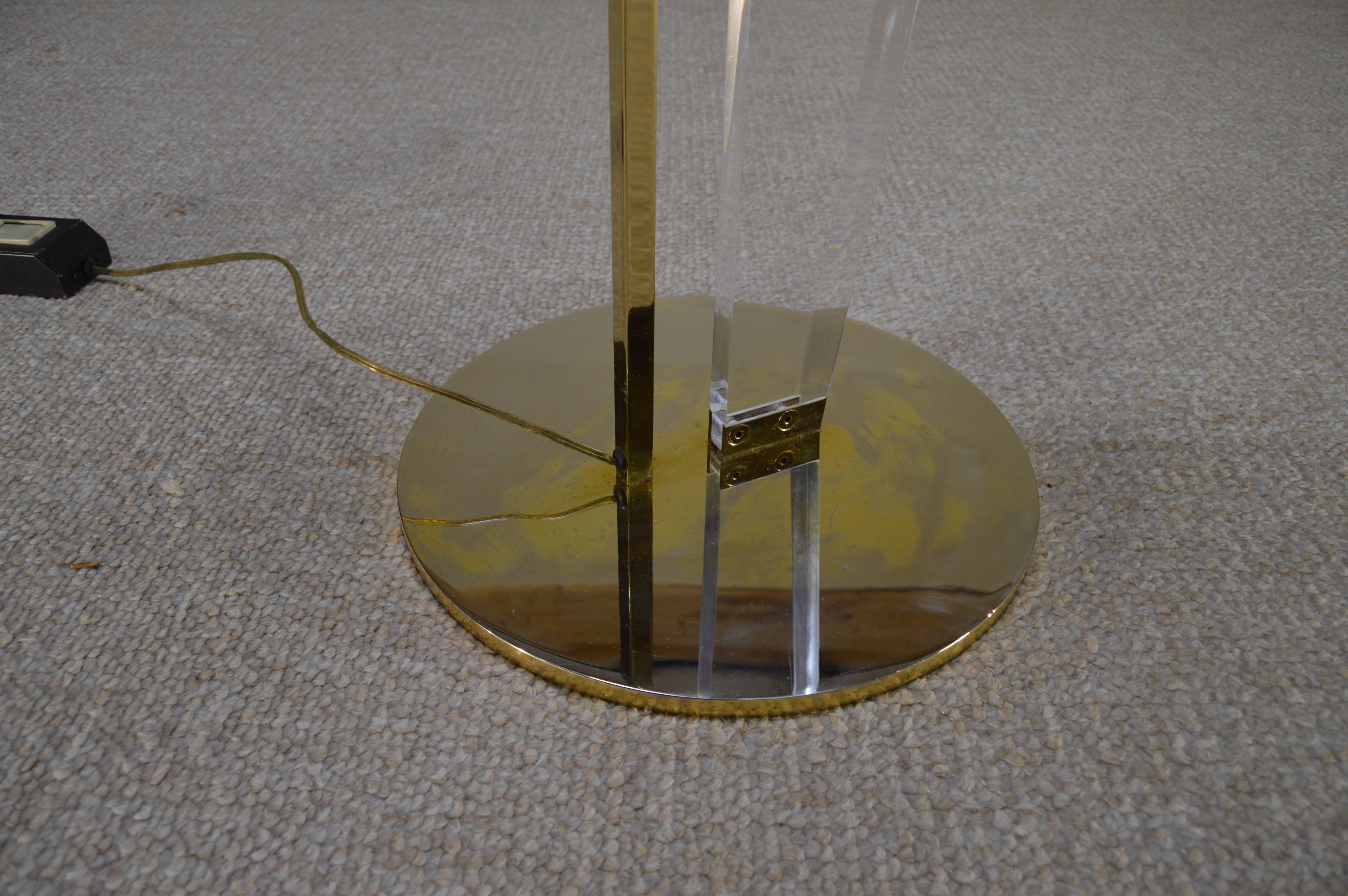 Hollywood Regency floor lamp having brass base with Lucite body that meet to support the brass shade. Features a floor slide off/on dimmer switch.
Beautiful condition having minor color fading to the base.