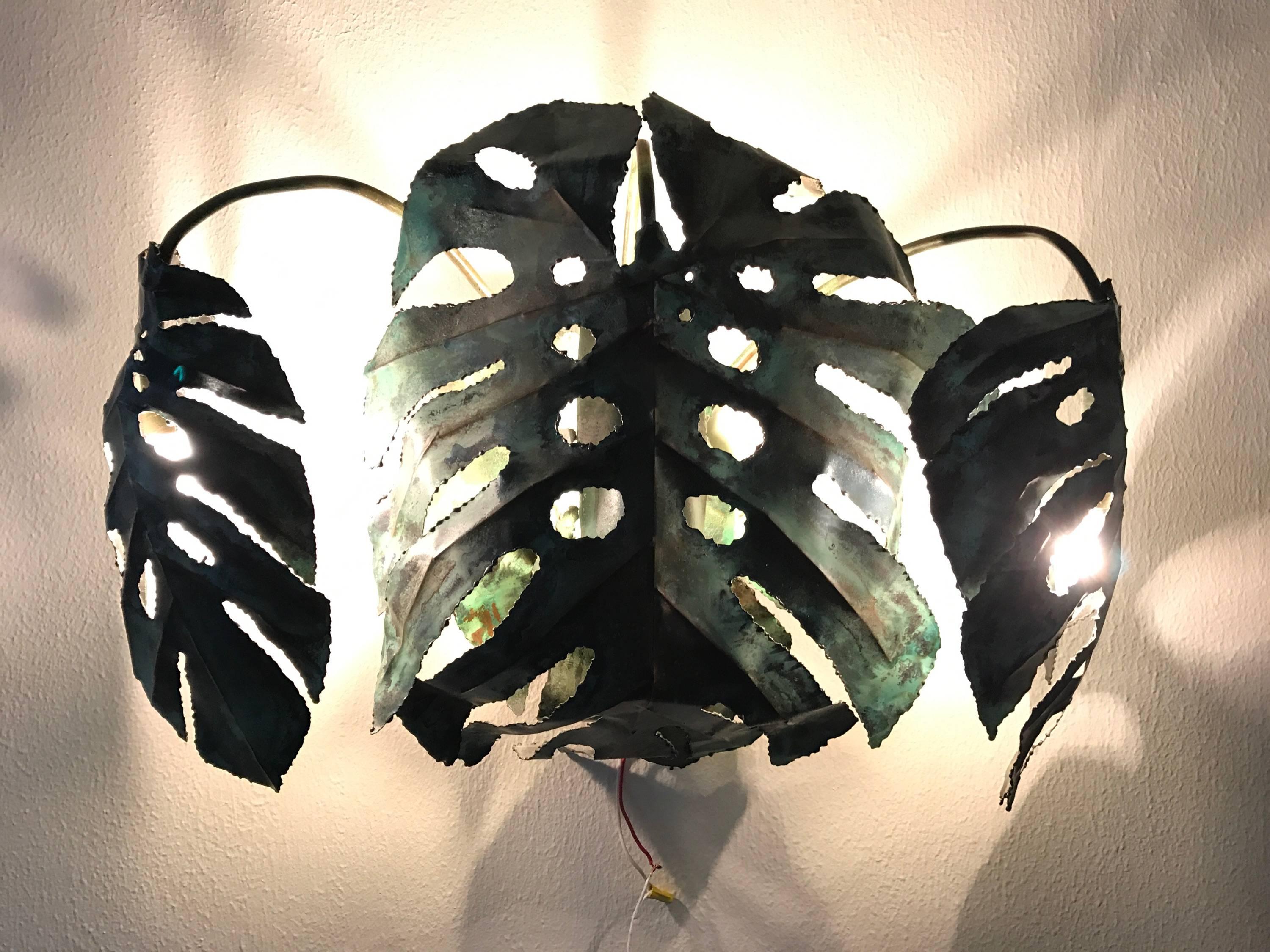 This is an original copper enameled wall sconce made in the 1960s by the late Garland Faulkner of Miami Florida.
Sculpted and executed to look like the Monstera deliciosa (Swiss cheese plant / hurricane plant) this artist signed enameled copper