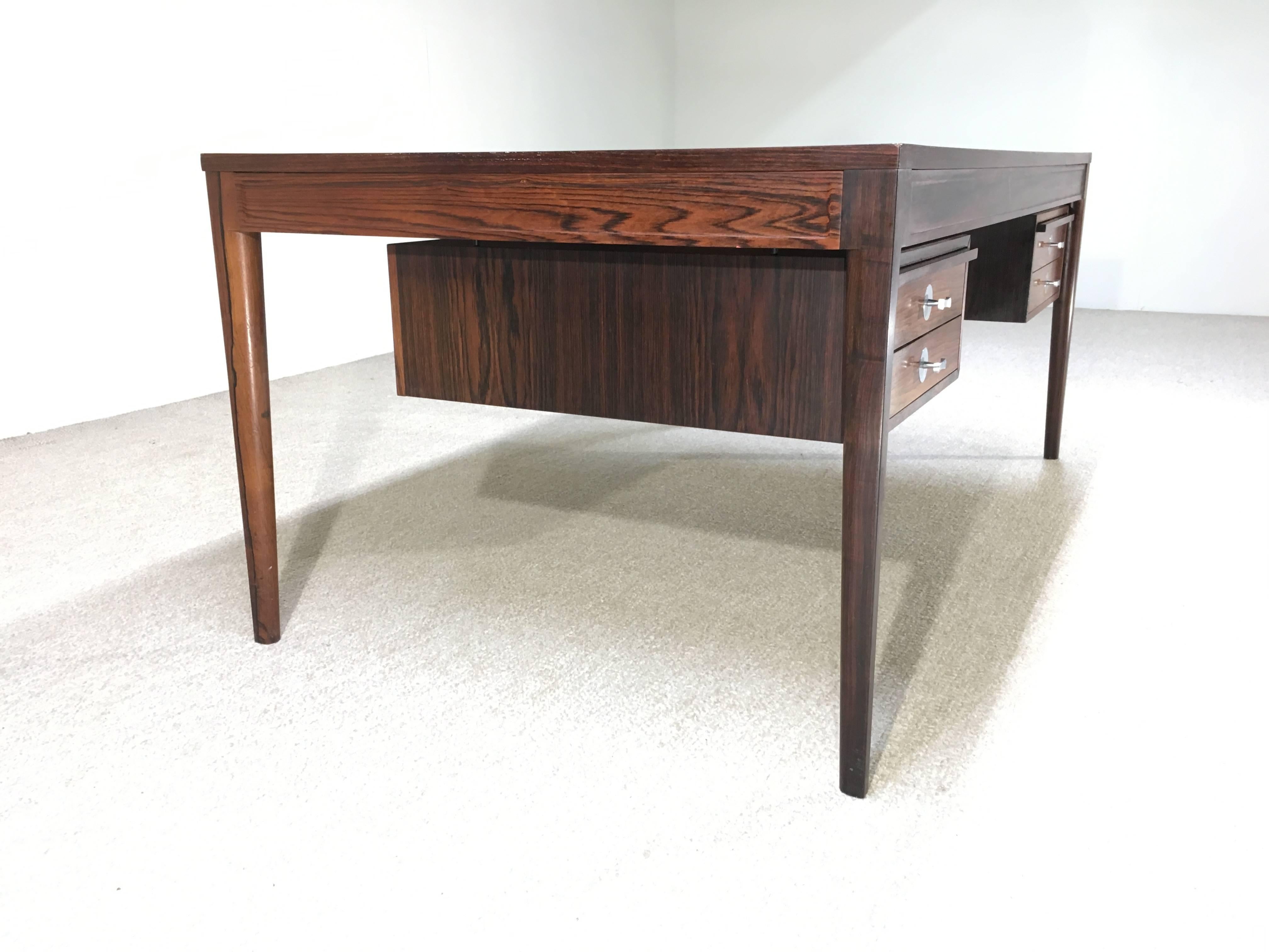 Gorgeous Finn Juhl diplomat desk in Brazilian rosewood having signature aluminium pulls and green felt dawned letter trays, one having a glass press. France and Son button underneath.
Very nice vintage condition having some retouches in areas.