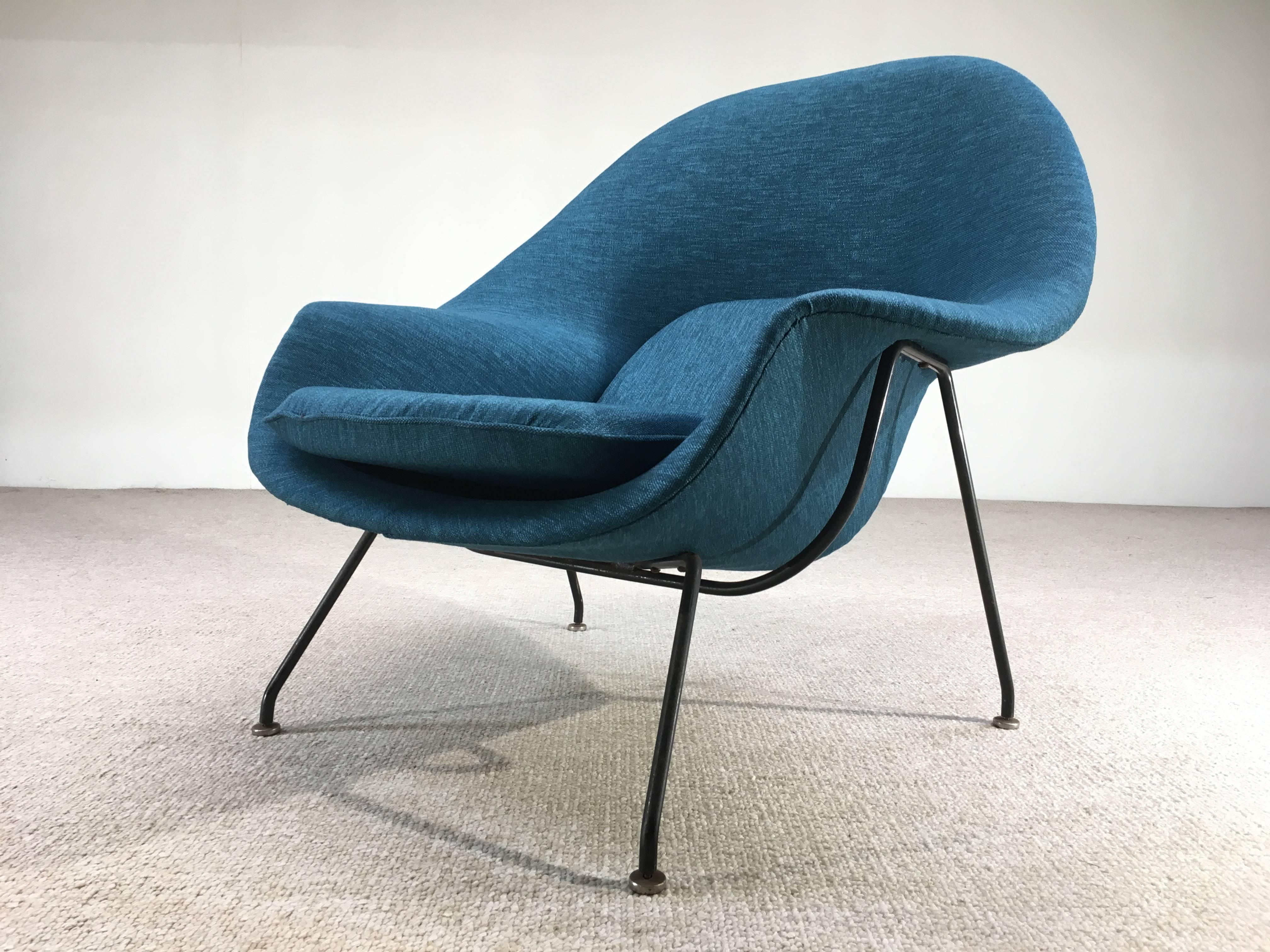 An early 3rd generation Eero Saarinen Womb chair having black iron base and signature stainless steel glides. Newly reupholstered in cotton/poly tweed. There are four tuft buttons underneath the cushion.