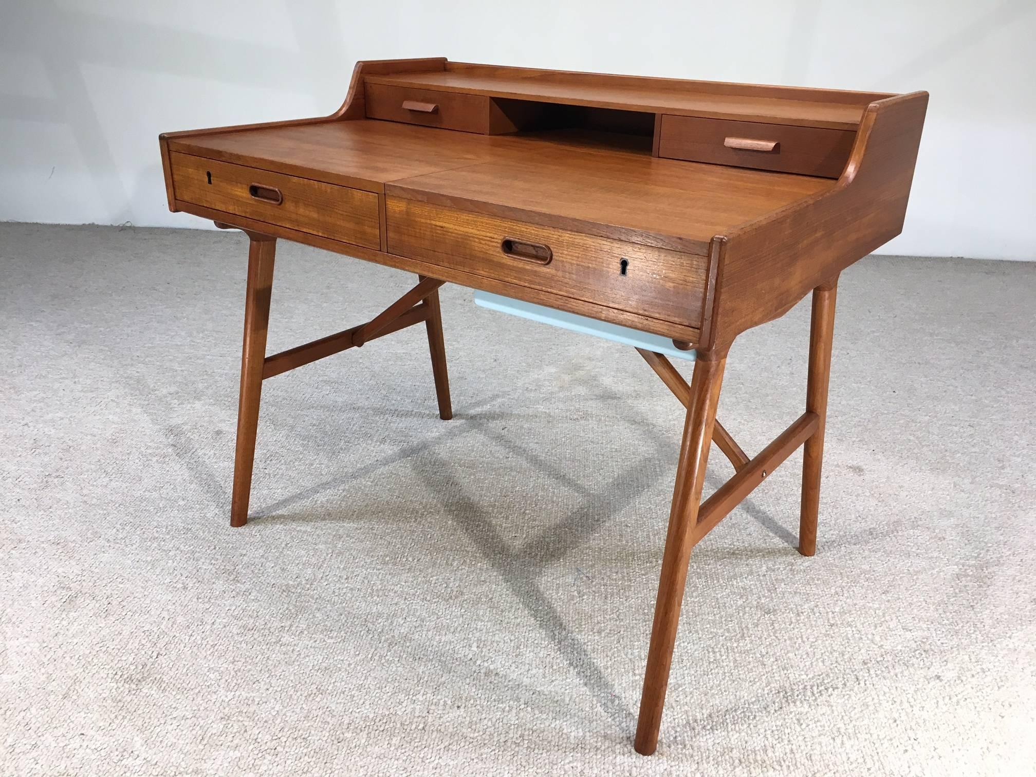 A rare and beautiful teak example from the Arne Wahl Iversen model 65 series having a flip up vanity mirror, turquoise accessory tray, red felt padded sliding jewelry storage cases and space inside of three drawers. 

Overall measurements in inches: