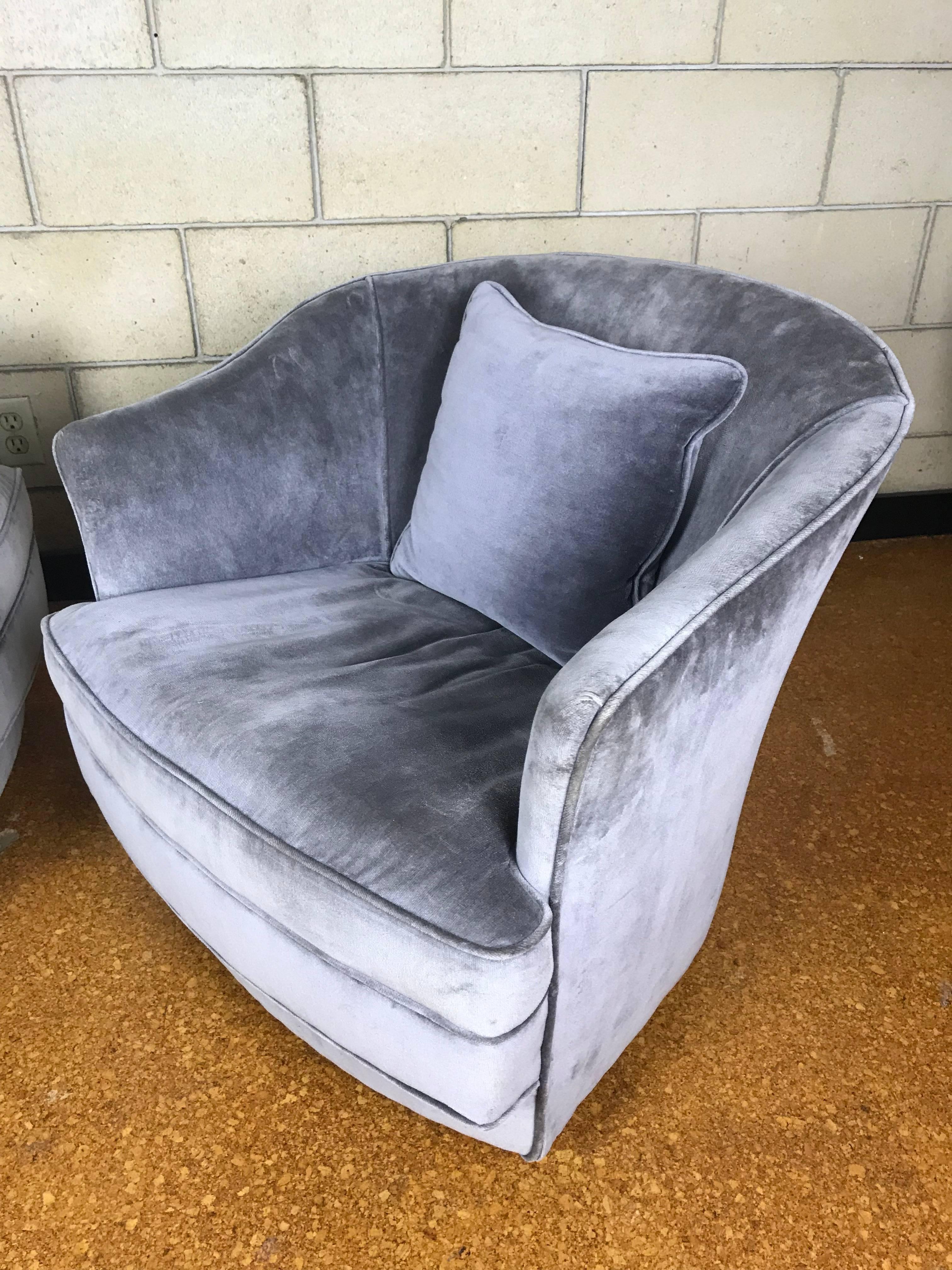 Rare pair of petite swivel club chairs in soft grey felt by Ralph Morse for the Ralph Morse Furniture Company. Each chair is on casters and they move silently and smooth. The original labels are under each chair - dated 11/12/1964. They were