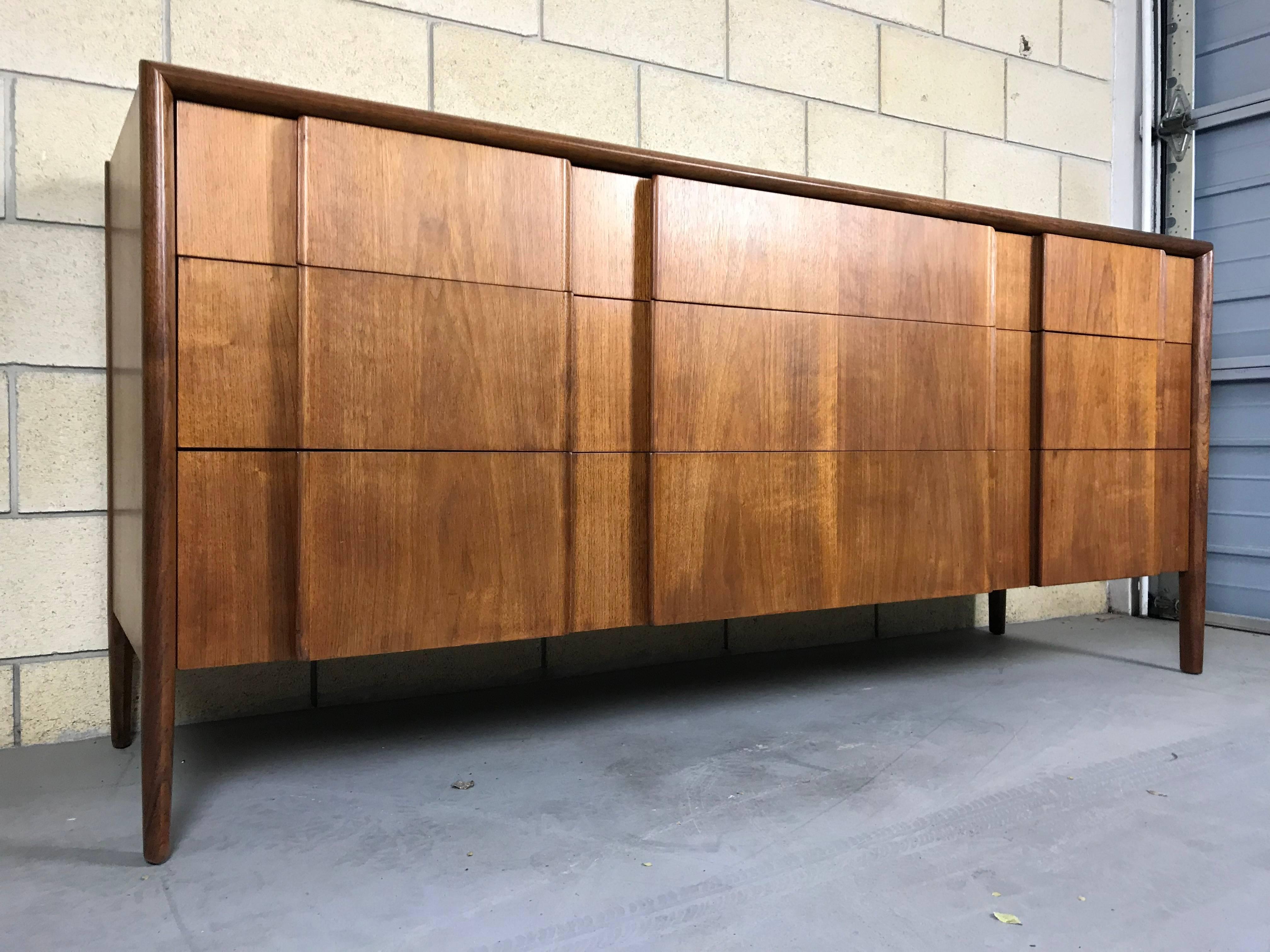 Beautiful Minimalist walnut nine-drawer dresser designed by Barney Flagg for Drexel; Parallel line. Date stamped Oct 14th 1959. Refinished. Small veneer chip filled-in on the bottom left drawer.