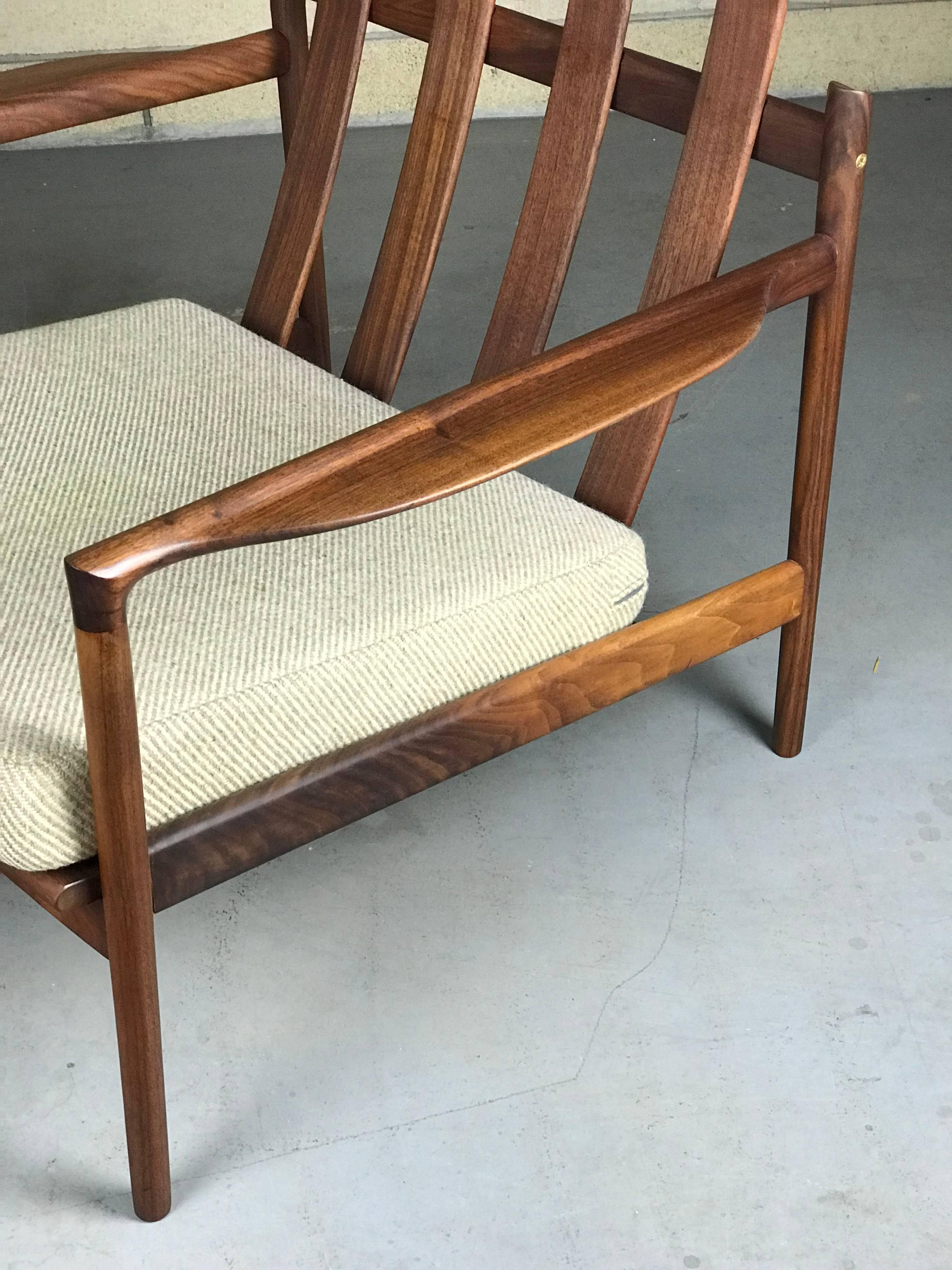 Beautiful and early rare split-back lounge chair designed by Ib Kofod Larsen for Selig. This is a very early model - unmarked, but authentic. New straps and clips. Refinished frame - a lot of the natural grain color came through and it looks