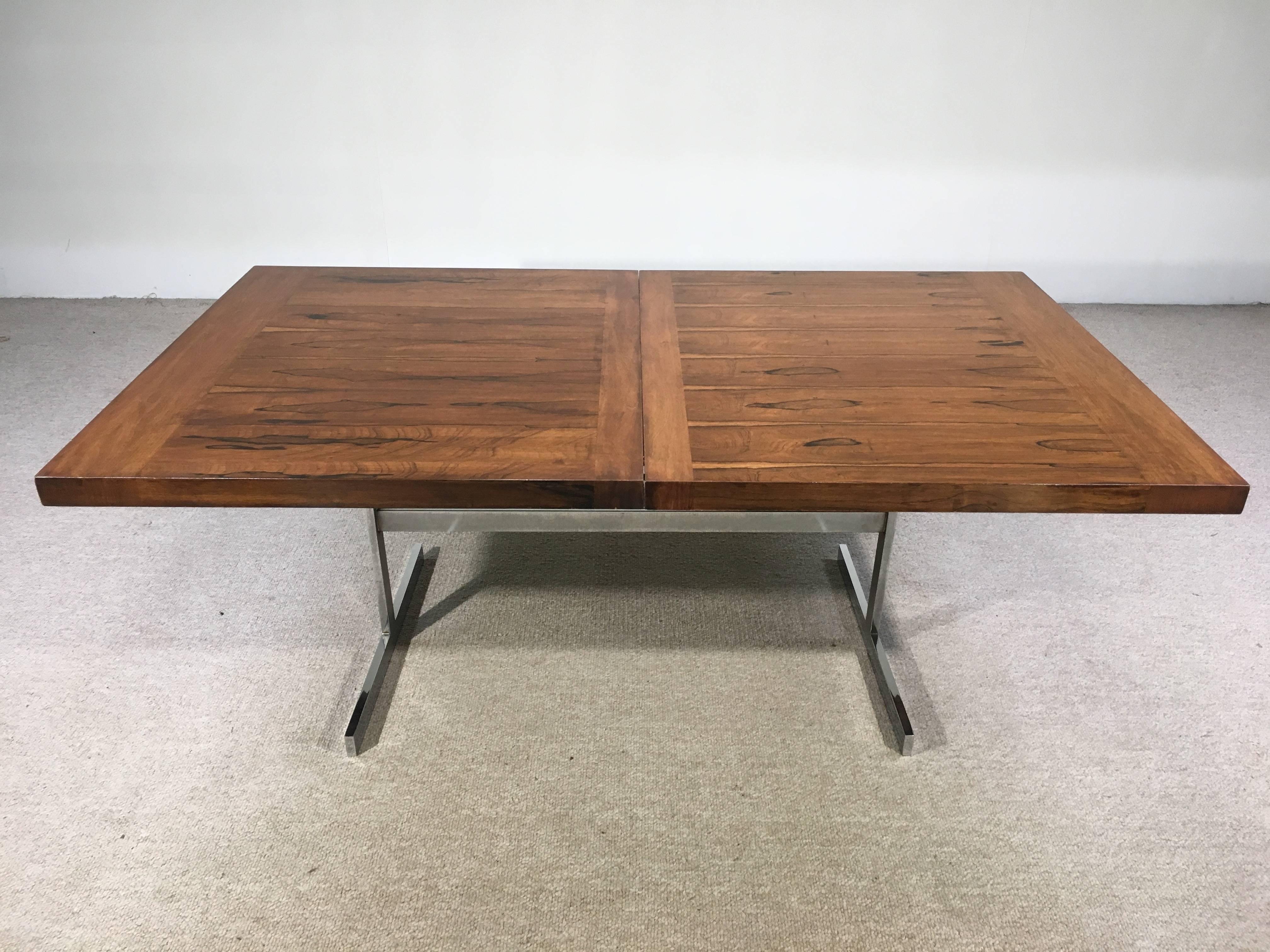 A beautiful and masterfully crafted 1960s expandable dining table after Milo Baughman having mixed Brazilian rosewood and walnut top with chromed steel base. Acquired from the original owner who has cherished this table and taken very good care of