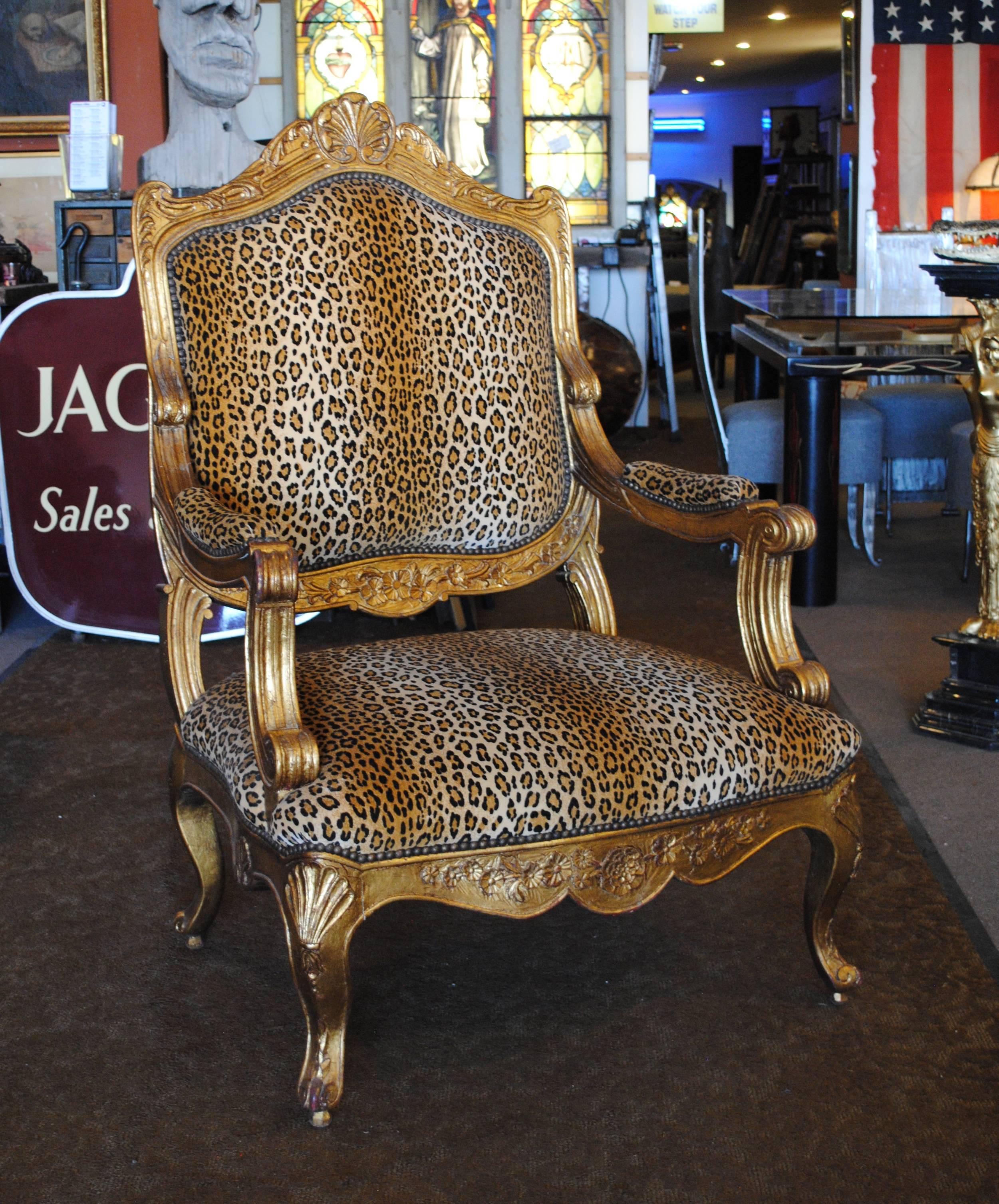 Louis XV style giltwood armchair. Upholstered in leopard print and nailhead trim. 
Dimensions: 32