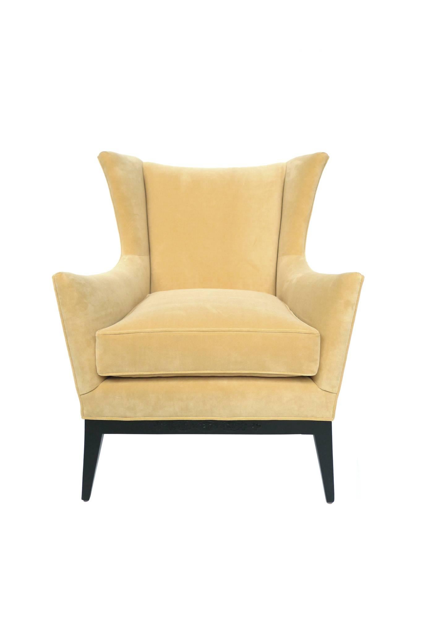 This well-tailored wingback armchair is attributed to James Mont, whose designs elegantly combined Modern and Art Deco designs. This chair is newly reupholstered in a soft, Naples yellow Duralee polyester velvet. The Fine piping is also done in this