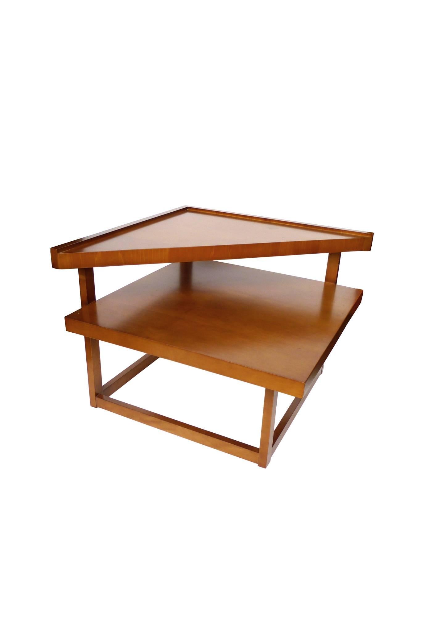 This Midcentury tiered corner table is by Brown-Saltman. It is blond mahogany, rich in hue and with a smooth surface. The modernist design is dynamic in form, making use of straight lines and simple shapes. This is an exceptional table that