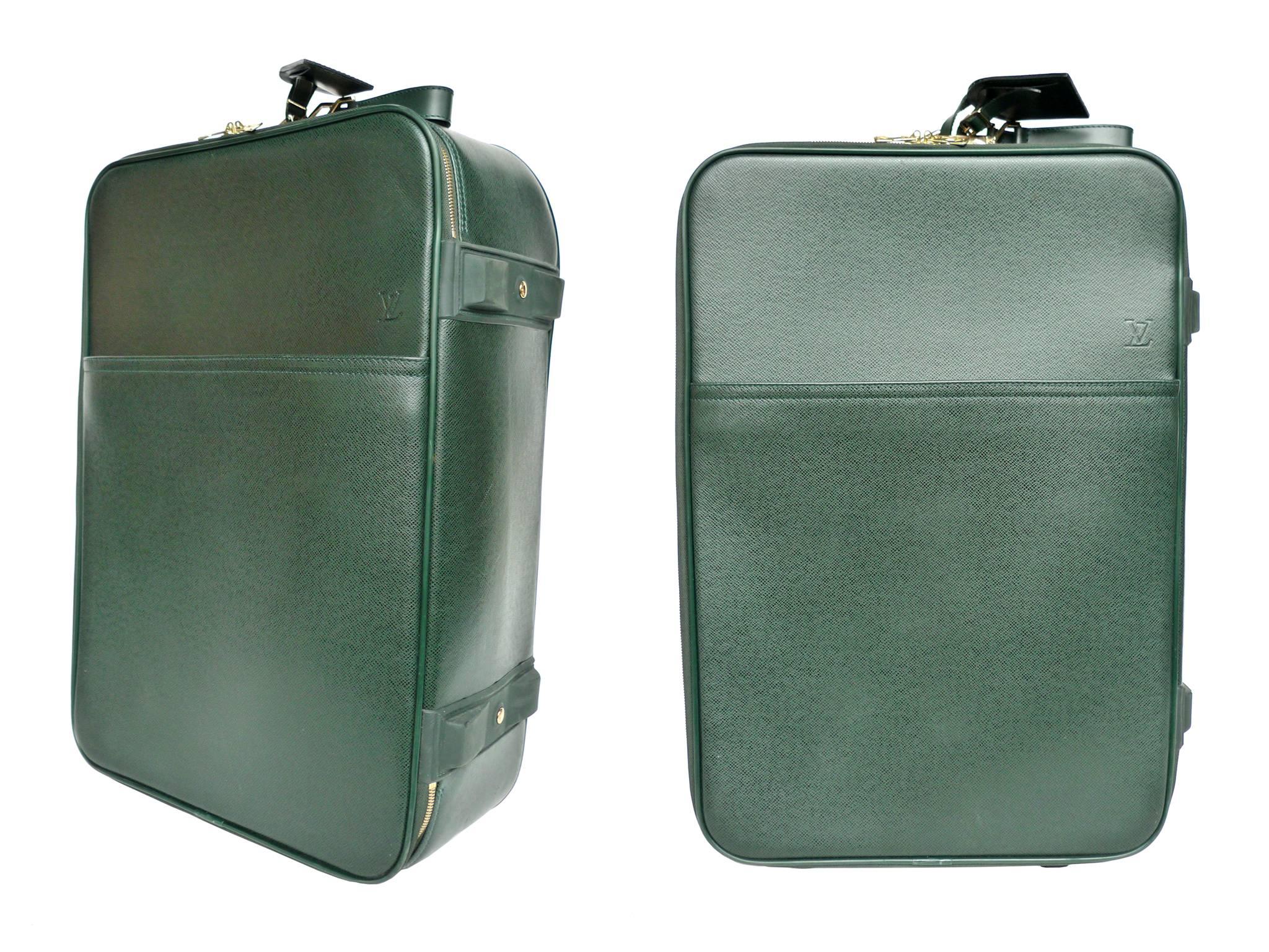 Pégase 55 is a small, compact Louis Vuitton travel suitcase. It is crafted from durable, soft Taiga leather in a rich hunter green color. Gold-hued zippers beautifully outline the sleek shape. The suitcase's functional features include: An exterior