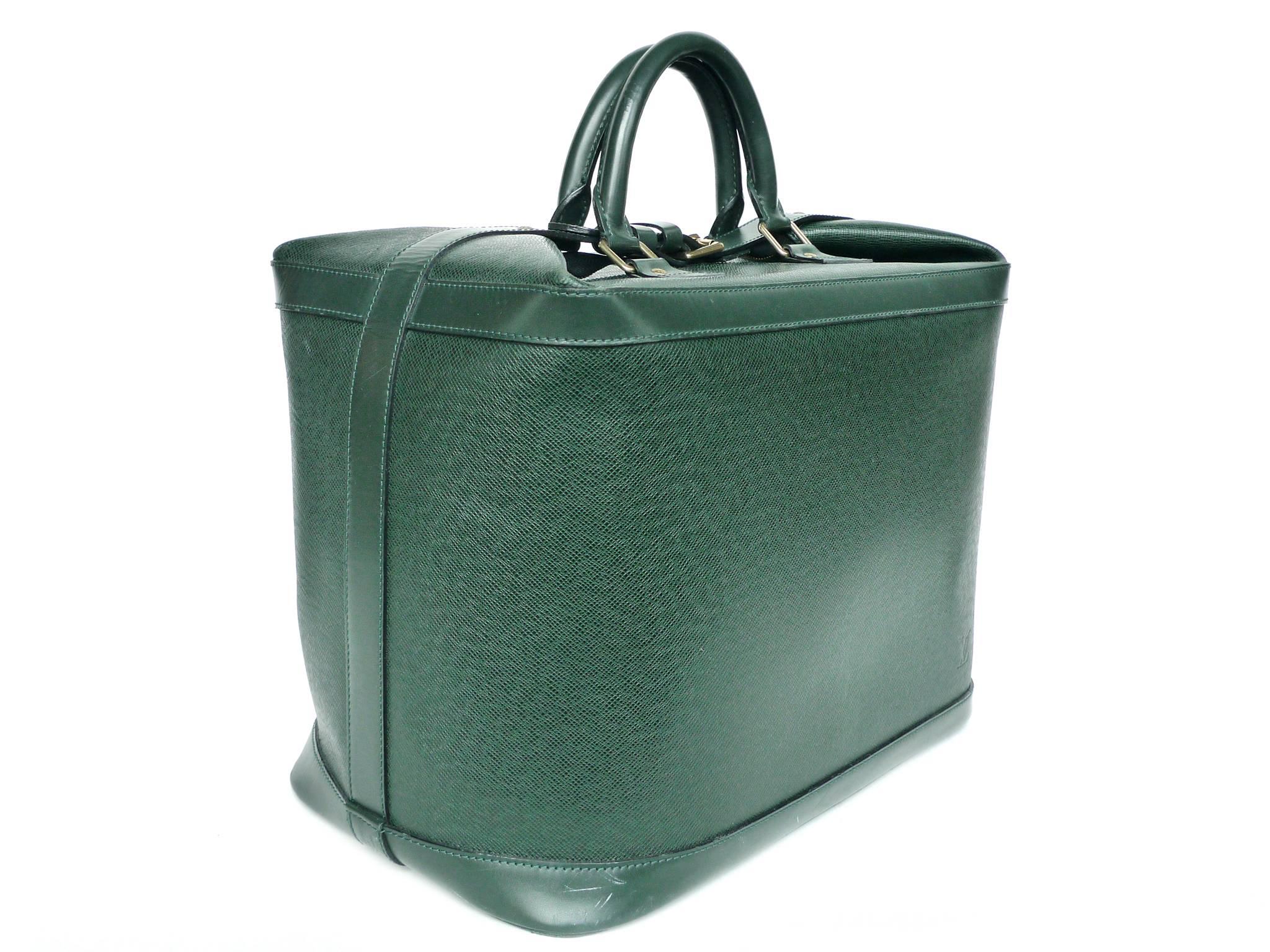 This Louis Vuitton Cruiser 40 travel bag is crafted from durable, soft Taiga leather in a rich hunter green color. Gold-toned brass hardware beautifully complement the compact box shape. The bag's interior is done in a green suede fabric. Other