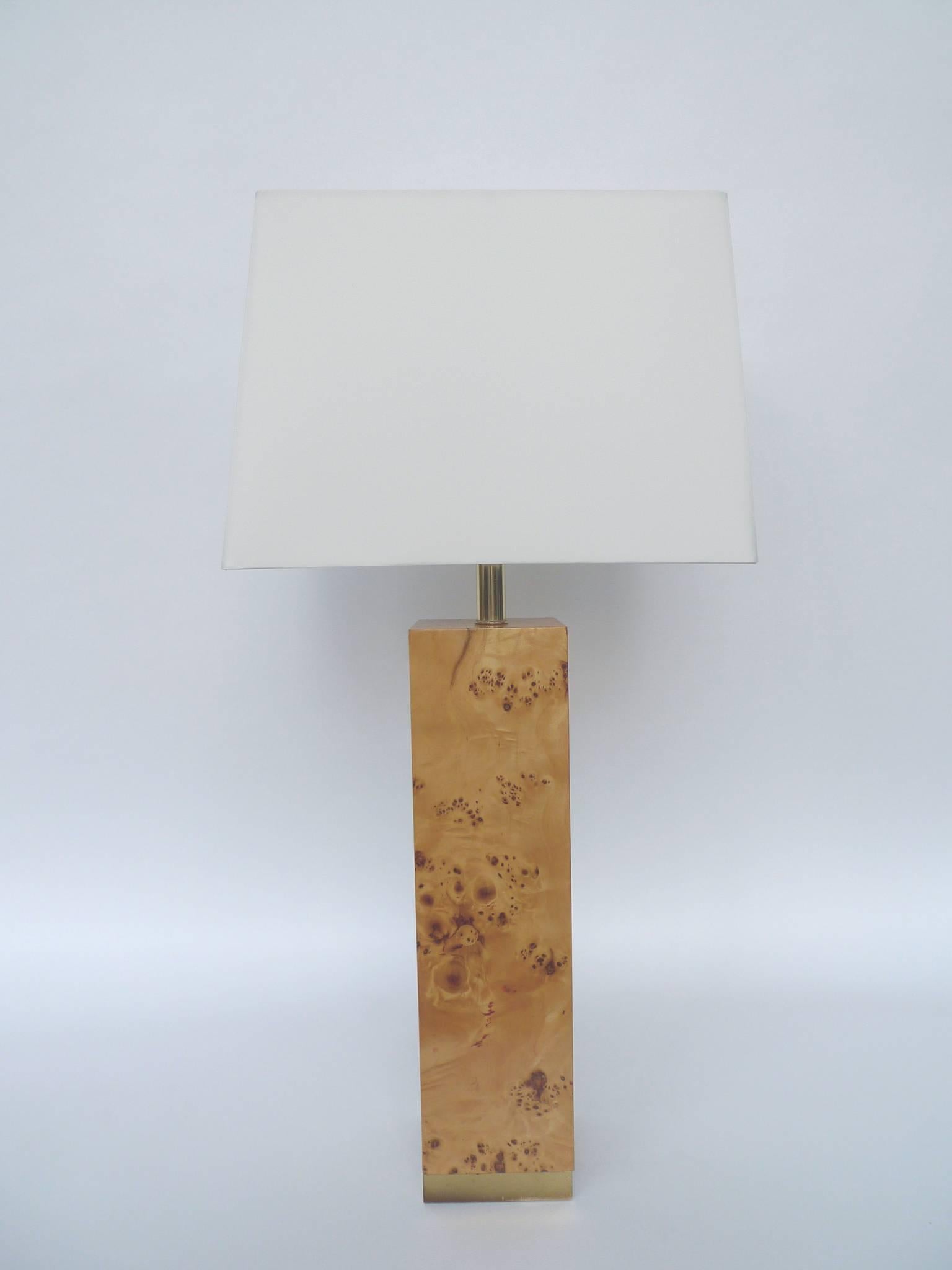 These columnar lamps are crafted from lacquered burl wood. They resemble the designs of Milo Baughman, whose work make beautiful use of simplicity and clean lines, utilizing the inherent qualities of the materials as the decorative elements of his