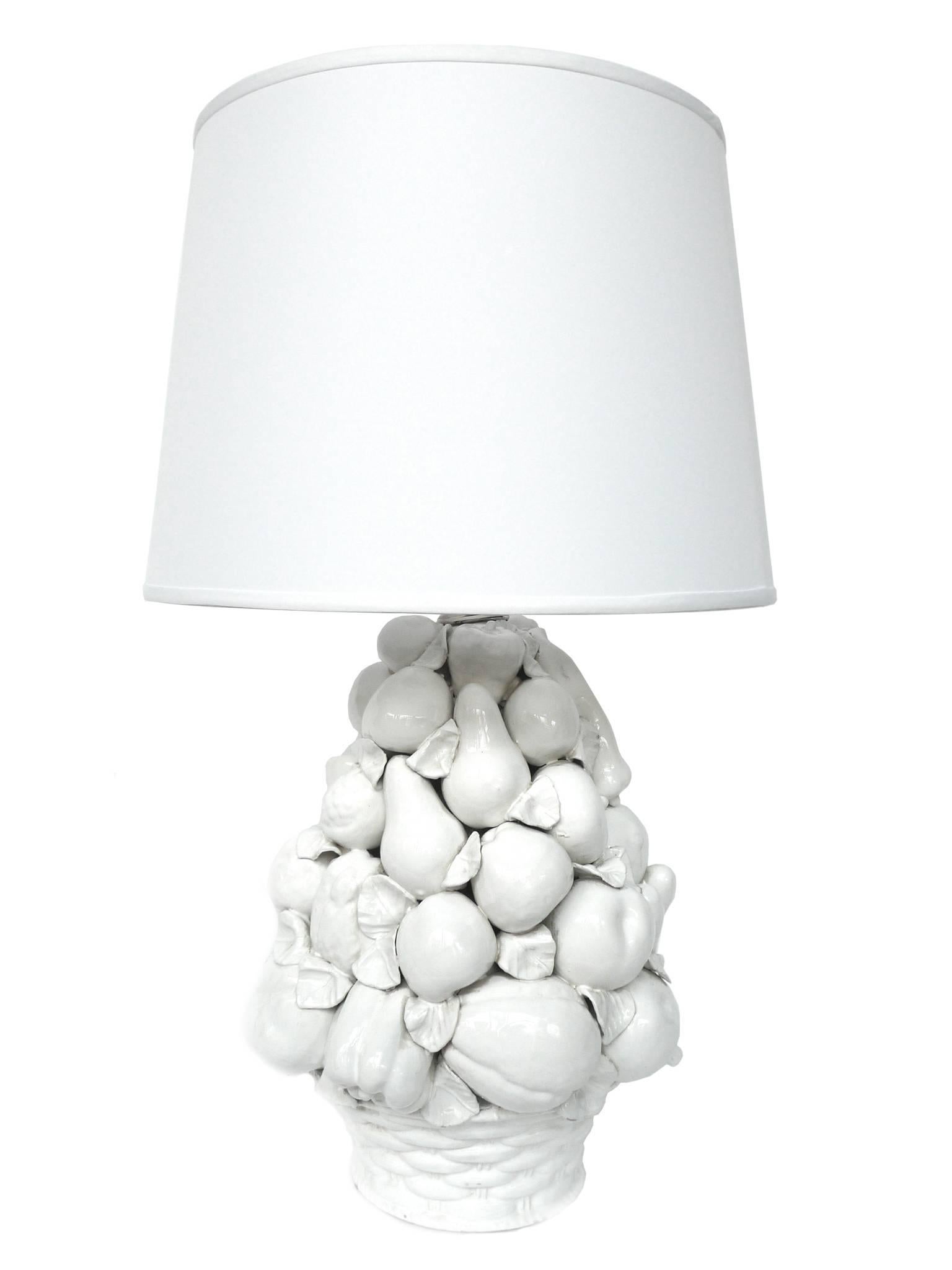 These ceramic lamps from Italy are in a lovely fruit-basket form in an all-white glaze. A closer look reveals very detailed features among the cluster of different fruits. The lamps are partnered with new silk drum shades. They are newly rewired and