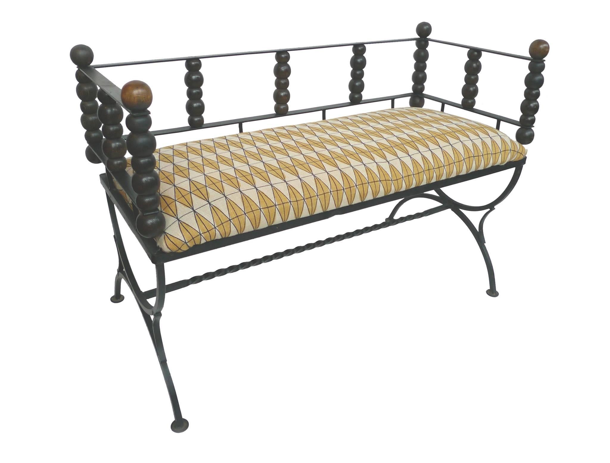 This small, charming 1960s bench consists of a wrought iron frame and carved oak ball details. The rich, yellow diamond-pattern textile is a design by the late Olga Lee Baughman.