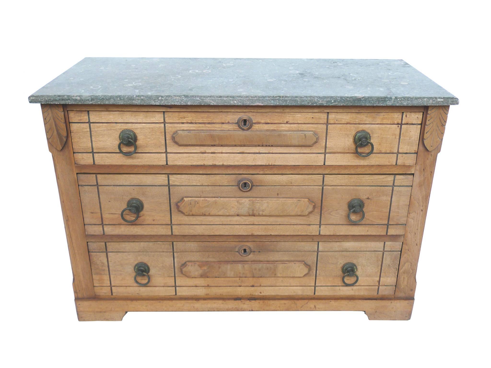 This late Victorian Eastlake dresser consists of a wood case, marble top, and brass pulls. The marble is a gray, 3/4-inch-thick, beveled slab with beautiful pale-pink rings in the grain. The case has three drawers with carved linear decoration. With