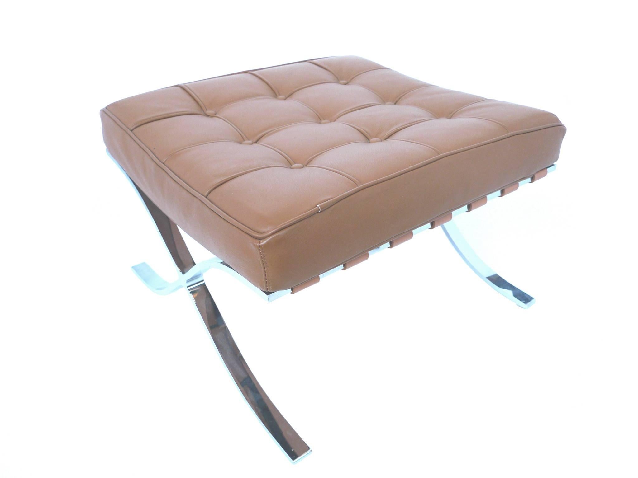 These 1970s leather ottomans are in the style of the Barcelona ottomans designed by Ludwig Mies van der Rohe. They have a tufted cushion and steel X-legs that curve outward. The cushion is secured to the base with leather straps. 

The leather is