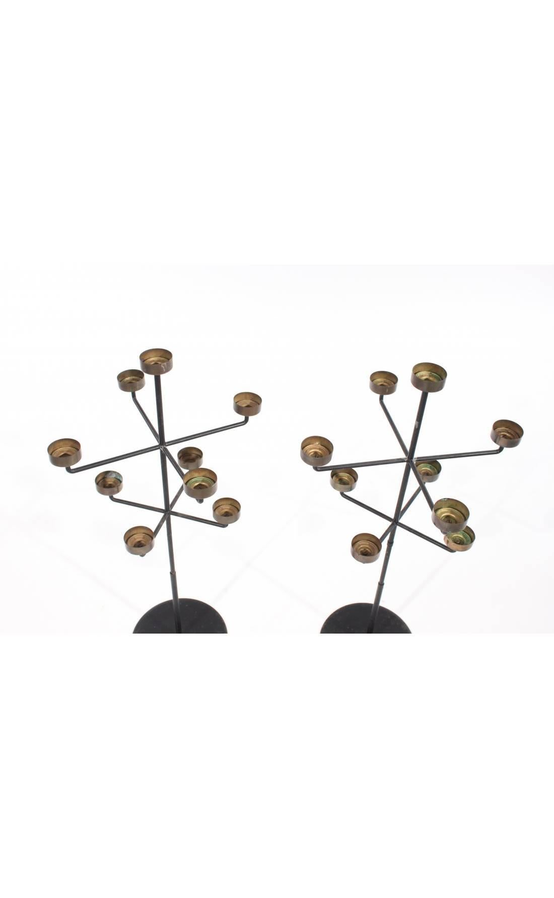 These Midcentury candelabras have a whimsical quality to their tree-like forms. They are minimally designed and are comprised of an iron stand and brass candleholders.

The candelabras are structurally sound. They sit evenly on a surface. However,