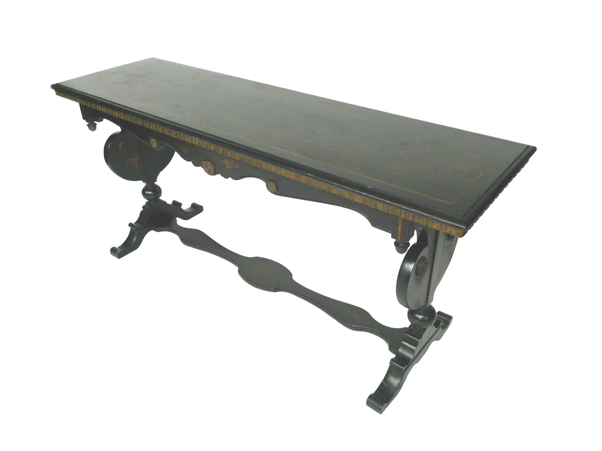 This 1940s chinoiserie console table is ebonized wood. Giltwood detailing adorns the skirt, surfaces, and legs, while a pastoral landscape is subtly painted on the tabletop, framed by a gilt border. The baluster legs are supported by a flat-topped