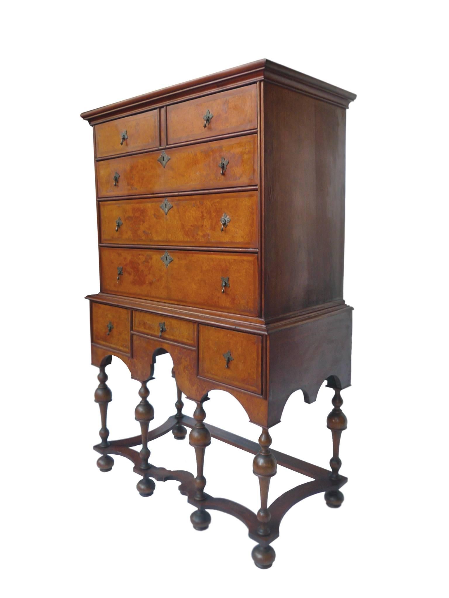 This late 17th century William & Mary highboy is beautifully crafted from mahogany. It is comprised of two detachable parts, the lower chest which has three drawers, and the flattop chest, which has five drawers. The wood has a reddish, warm tone