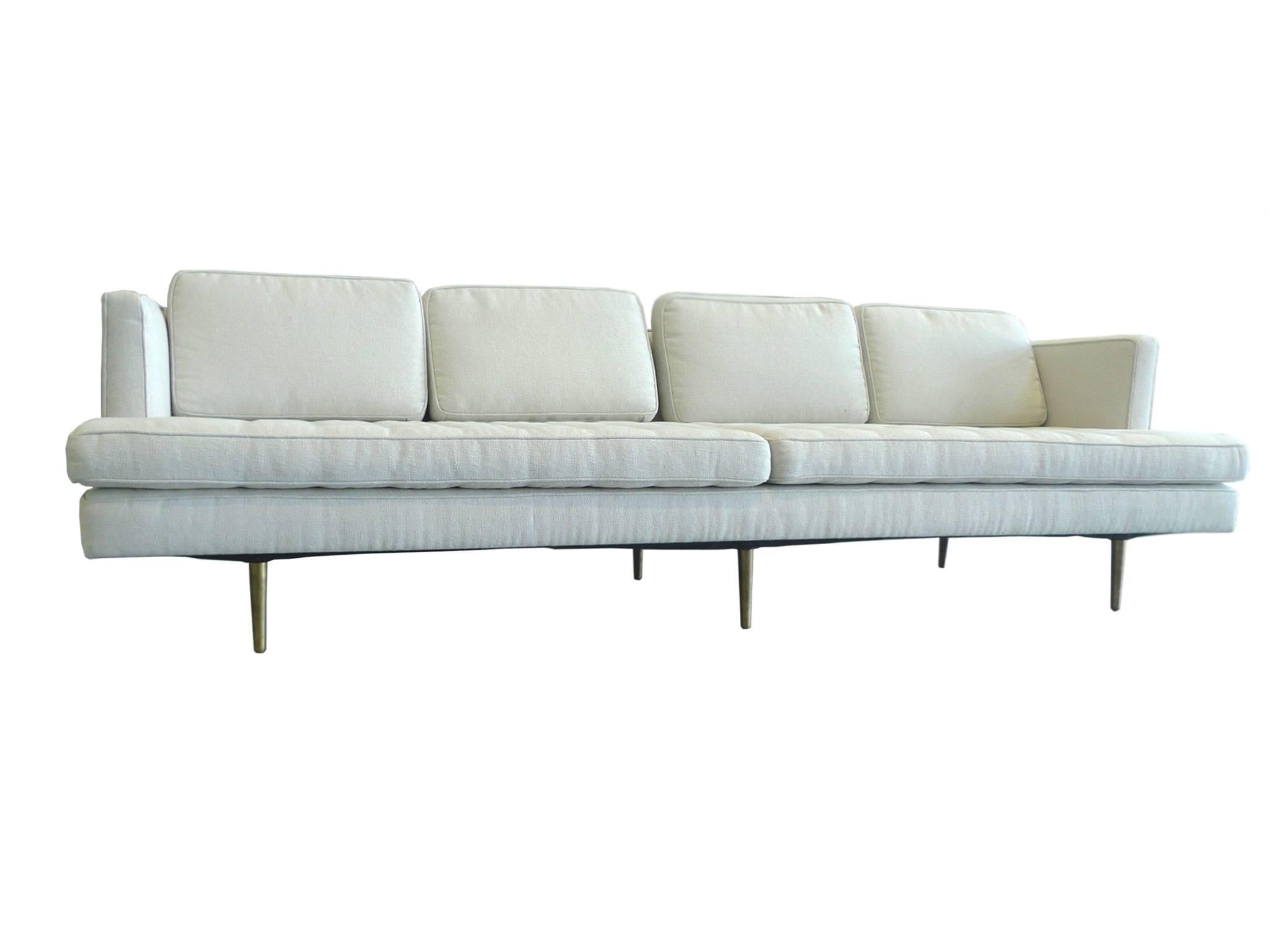 This sofa was designed by Edward Wormley for Dunbar. It is newly reupholstered in an oatmeal-white cotton bouclé. Like many of Wormley's modern designs, this sofa has clean, Stark lines punctuated by subtle decorative elements. They include the six