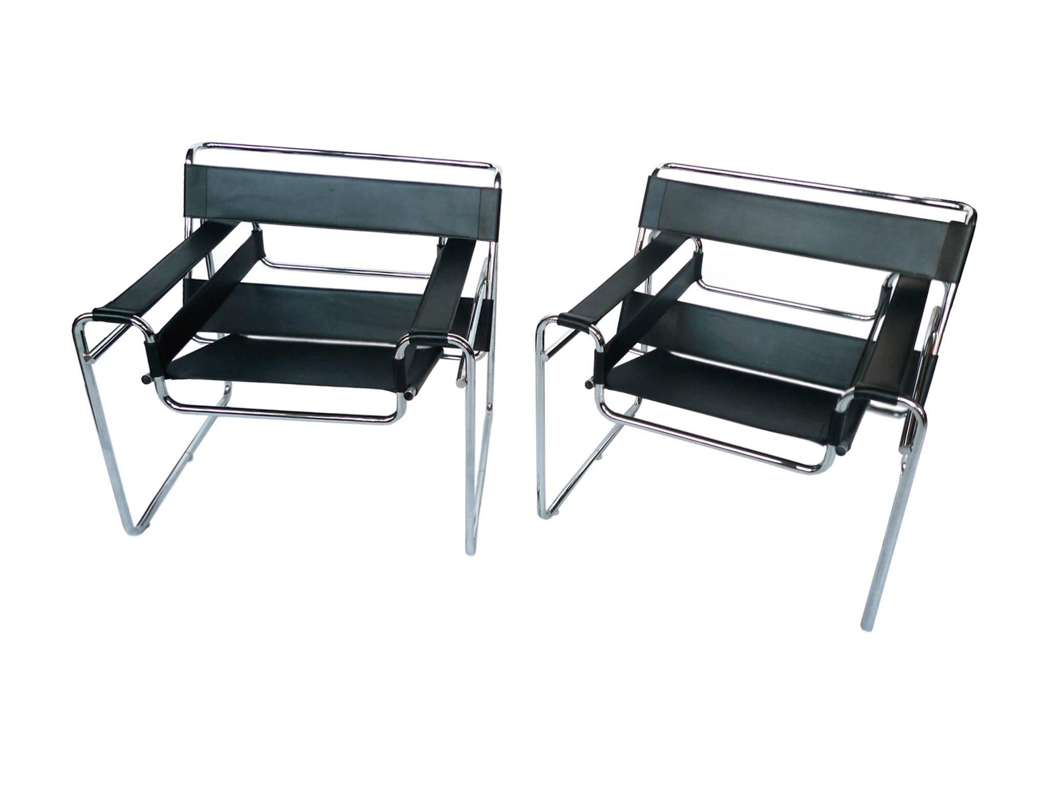 Designed circa 1925 by Marcel Breuer, these Wassily chairs have tubular steel frames and black leather seating, backing, and armrests. It's a beautiful, modernist design offering transparency with its minimalist lines and planes. The seat slopes