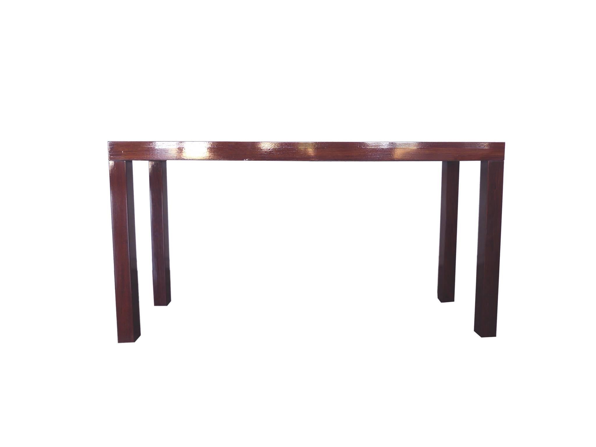 This Danish parsons console table was designed and manufactured by Dyrlund. It's made from mahogany wood, which has been newly lacquered to attain an eye-catching sheen. The lacquer also beautifully coats the wood's natural grain and deep red-brown