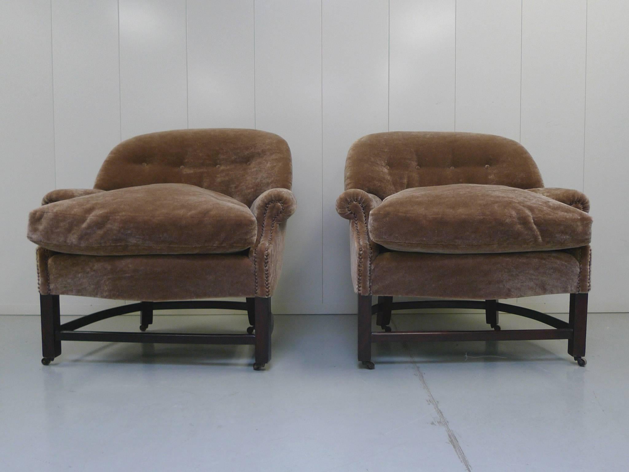 These barrel-shaped club chairs were manufactured, circa 1950s. They are very comfortable with soft, plush cushions and tufted back seats. The new reupholster work is taupe-champagne mohair. The curve of the chair's back is echoed in the structure