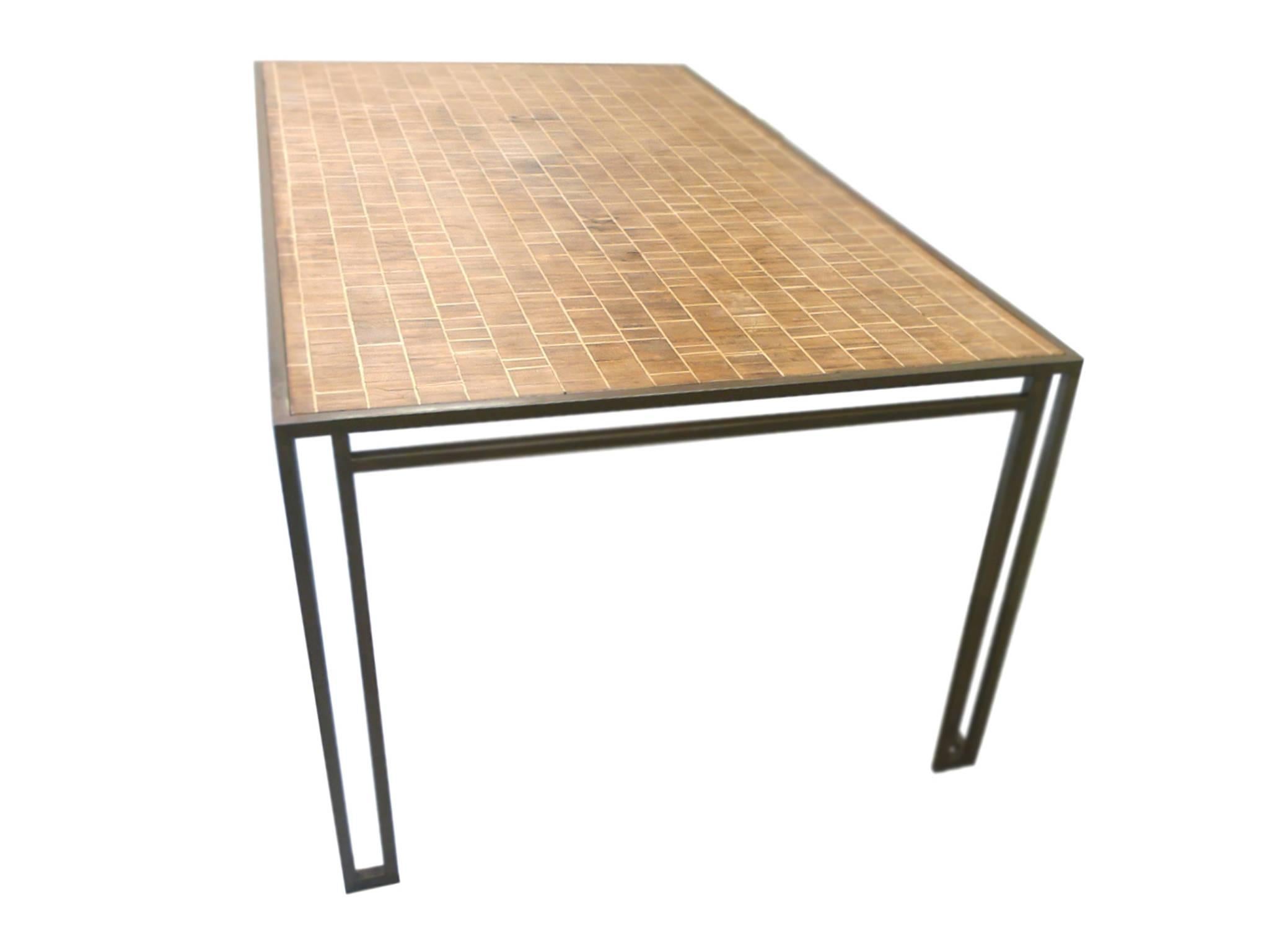 This 1970s dining table was designed by American interior decorator Billy Baldwin. It is comprised of an iron base and wood inlay top. The design is simple and elegant: the base makes use of slick Art Deco lines in its openwork structure, while the