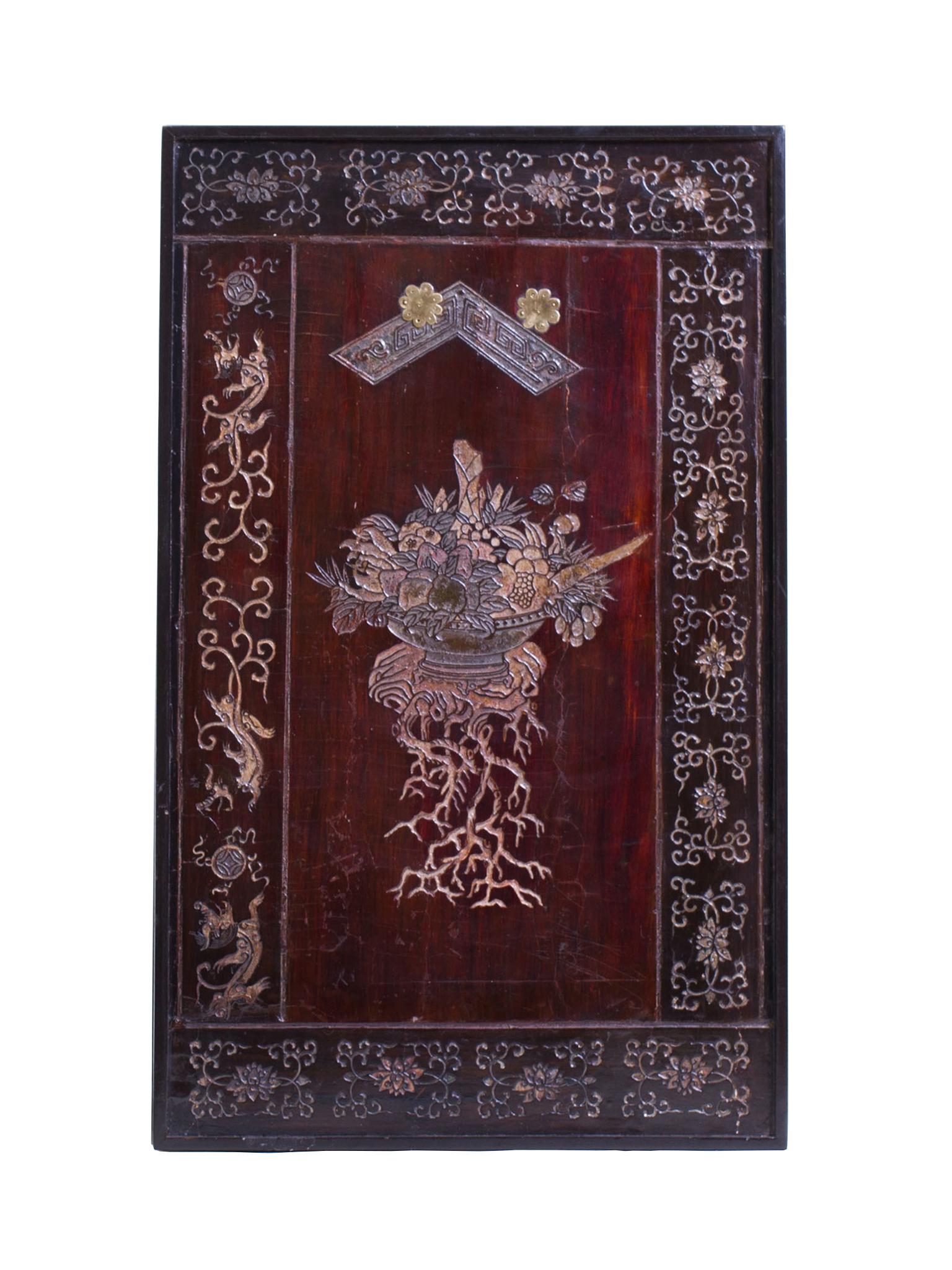 This Chinese low table was created in the early 20th century. It is comprised of a wood panel mounted as a floating tabletop. The panel is coated with Coromandel lacquer and designed with intricately incised patterns. Floral still-life imagery